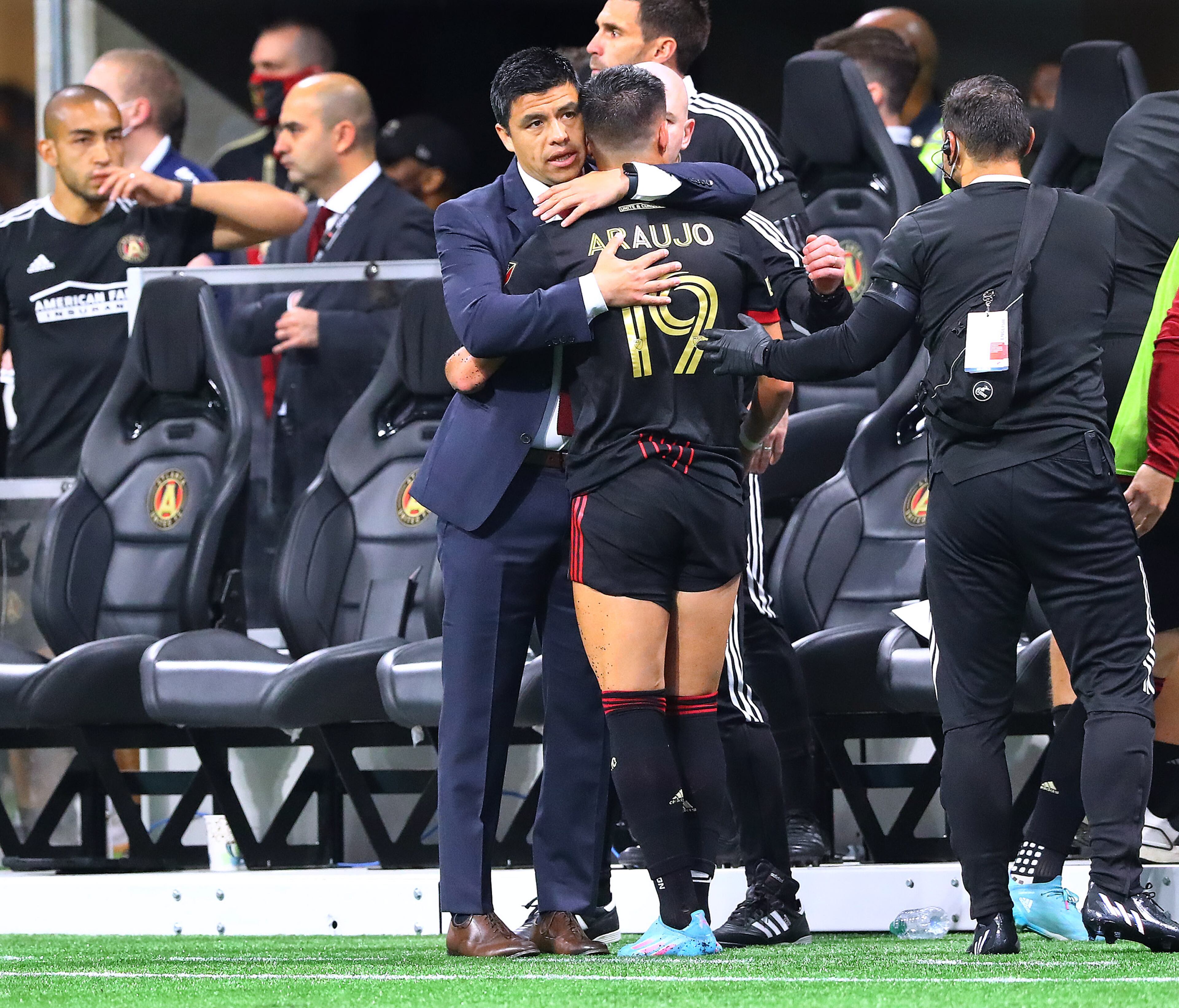 022722 : Atlanta United manager Gonzalo Pineda gives attacker Luiz Araujo a hug as he has to come out of the game with an apparent injury shortly after scoring a goal against Sporting KC for a 1-0 lead in an MLS soccer match on Sunday, Feb. 27, 2022, in Atlanta. “Curtis Compton / Curtis.Compton@ajc.com”`