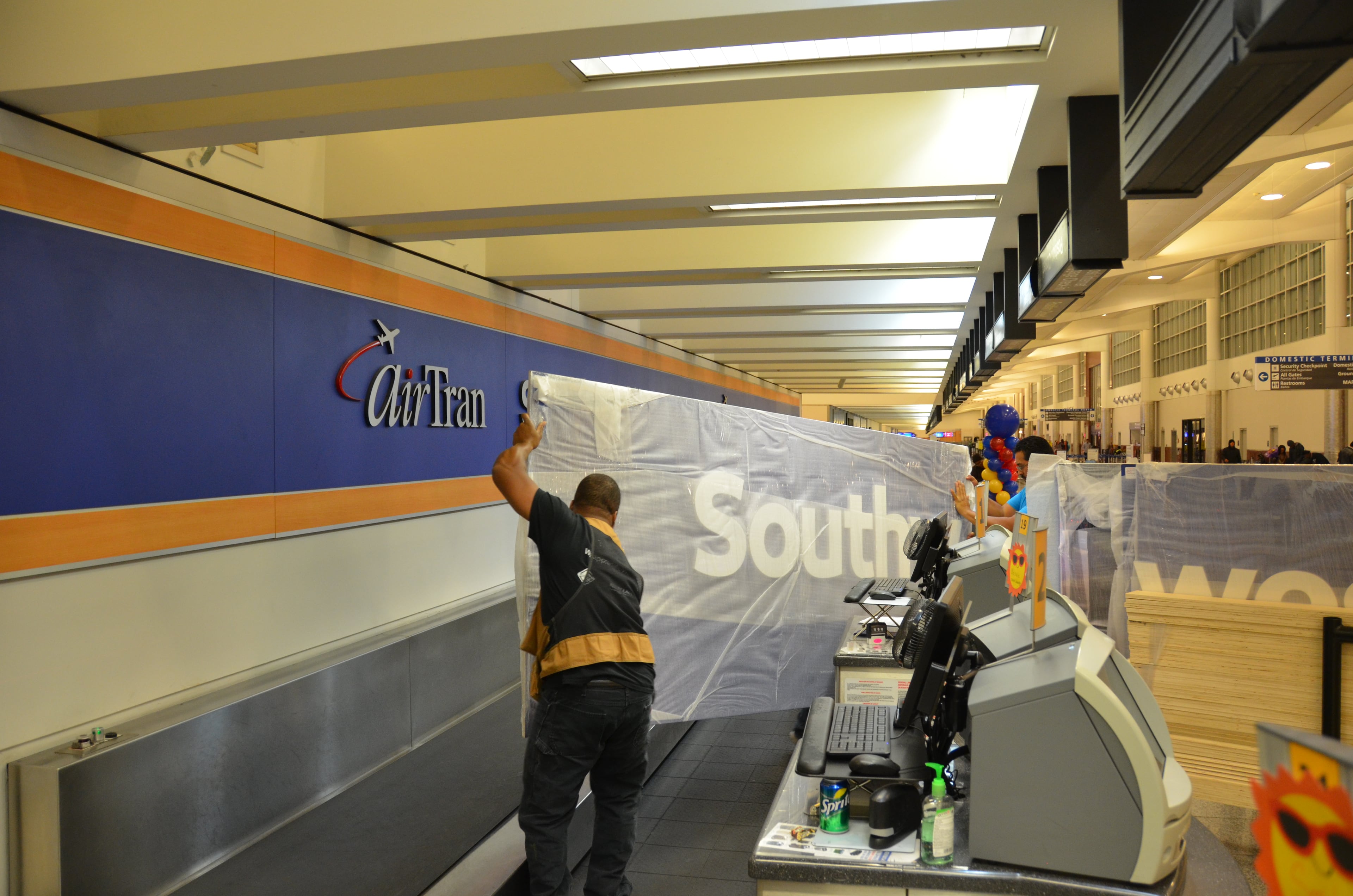 Contractors for Southwest Airlines took down the AirTran Airways signs at Hartsfield-Jackson International Airport, removing some of the last vestiges of the name at AirTran's former Atlanta hub. Dallas-based Southwest, which acquired AirTran in 2011, replaced the signs with its own new logo.