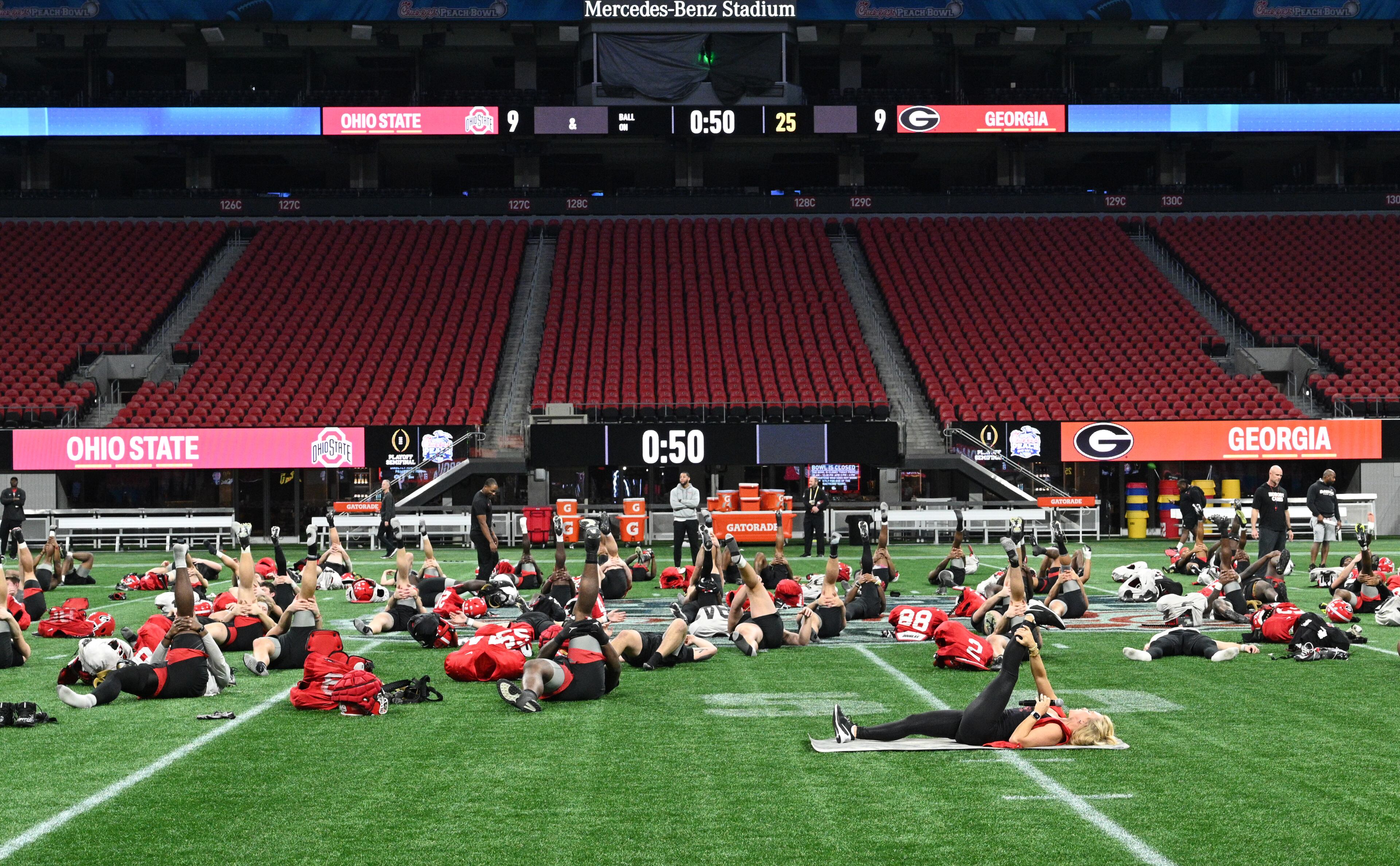An instructor (foreground) leads a stretch session for Georgia players during a practice session for the Chick-fil-A Peach Bowl game against Ohio State at the Mercedes-Benz Stadium on Thursday, Dec. 29, 2022, in Atlanta. (Hyosub Shin / Hyosub.Shin@ajc.com)