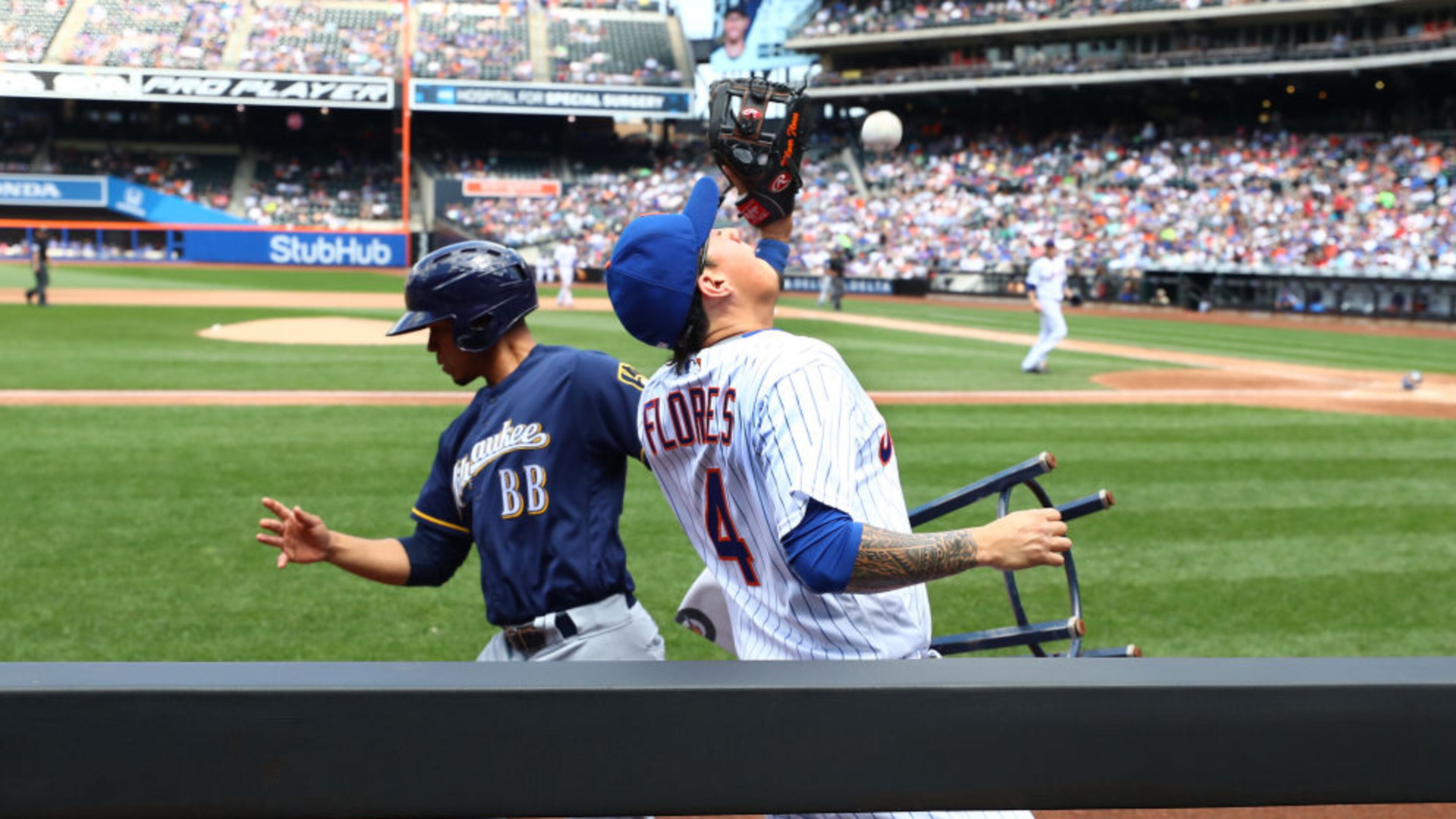 The bat boy tries to avoid Wilmer Flores of the New York Mets on a foul ball hit by Eric Sogard of the Milwaukee Brewers during the fourth inning of Thursday's game in New York.