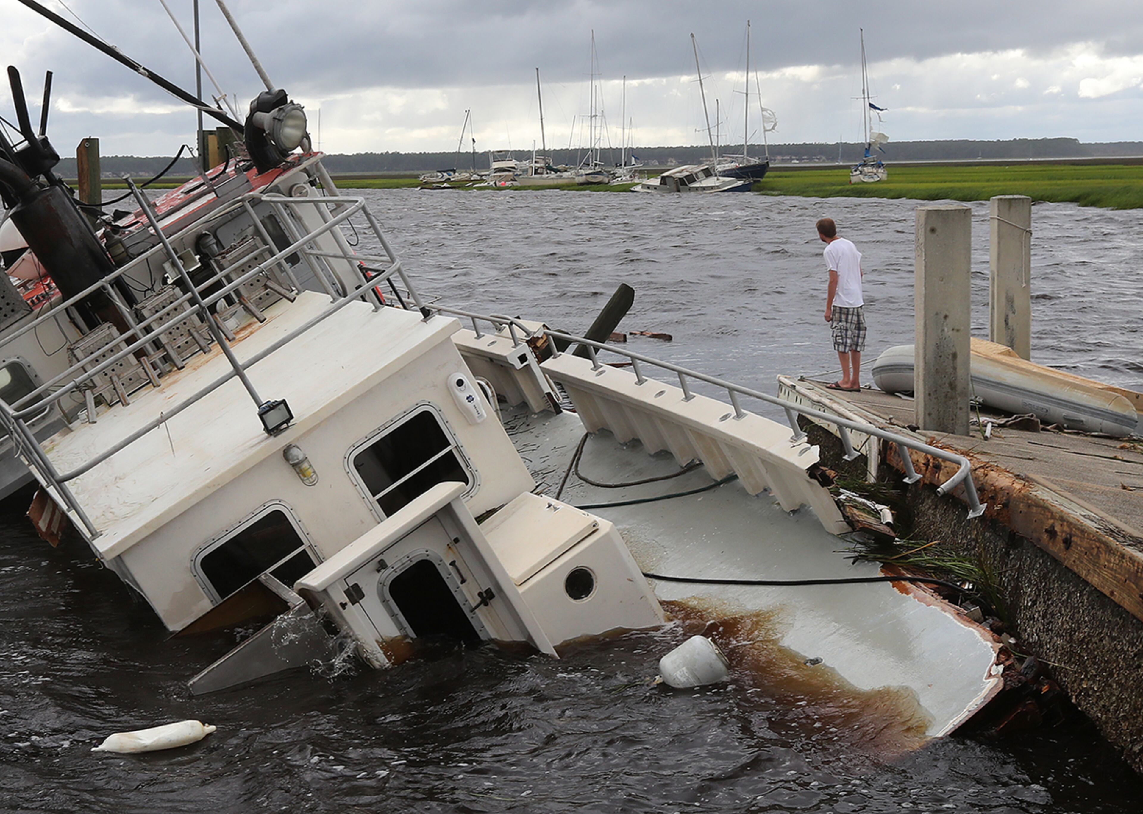 September 11, 2017 St. Marys: Dozens of boats are blown into the marsh and a shrimp boat sits on the bottom as local resident Michael Whitemore, 36, checks to see if a friendââ¬â¢s boat survived at Langs Marina after Hurricane Irma hit the town on Monday, September 11, 2017, in St. Marys. Curtis Compton/ccompton@ajc.com