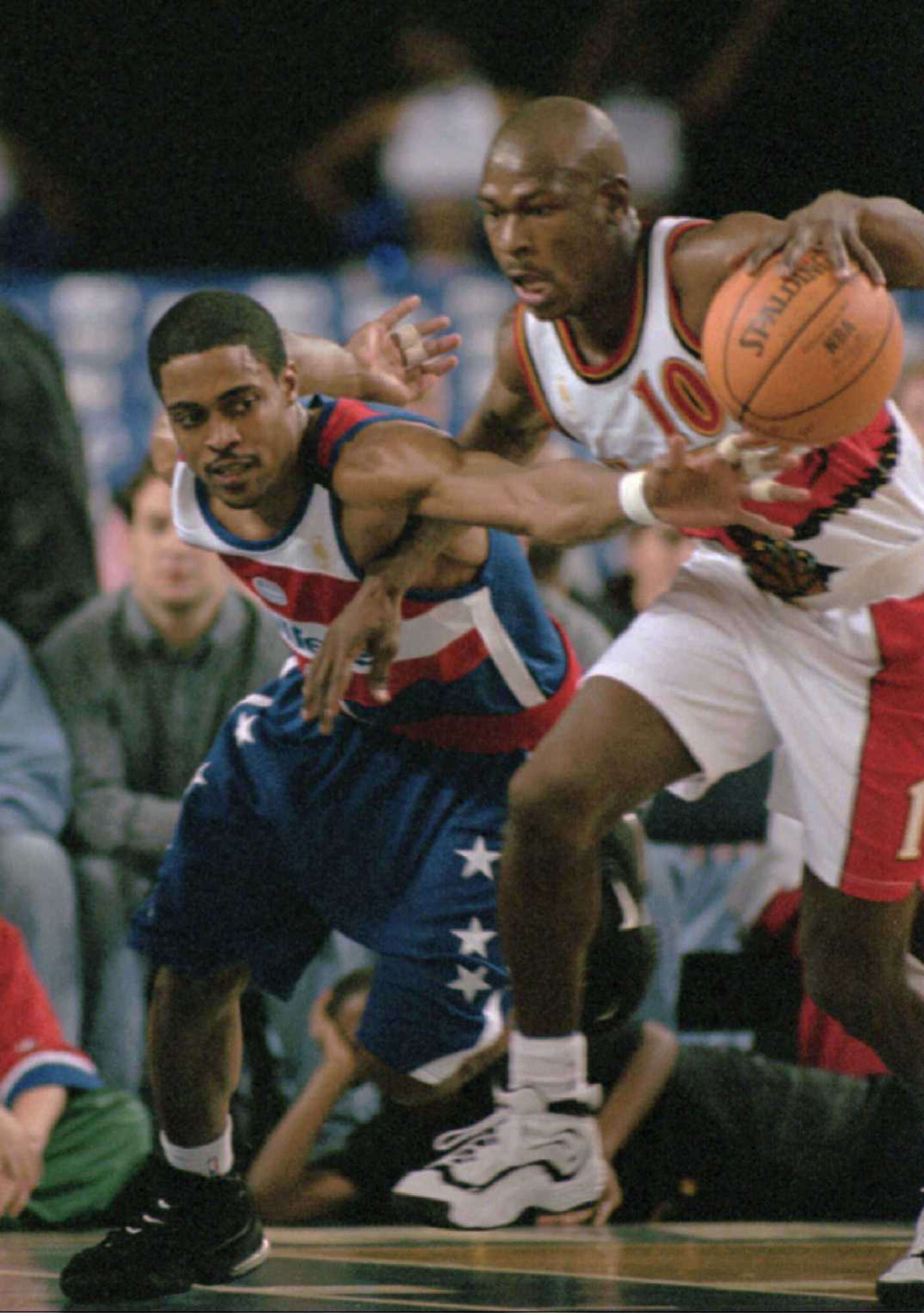 Washington Bullets guard Rod Strickland reaches in to Atlanta Hawks Mookie Blaylock in first period action Saturday night, Dec. 28, 1996 at the Baltimore Arena. In honor of the 50th anniversary of the NBA, the Bullets were wearing their retro 1973 uniforms. (AP Photo/Dave Hammond)
