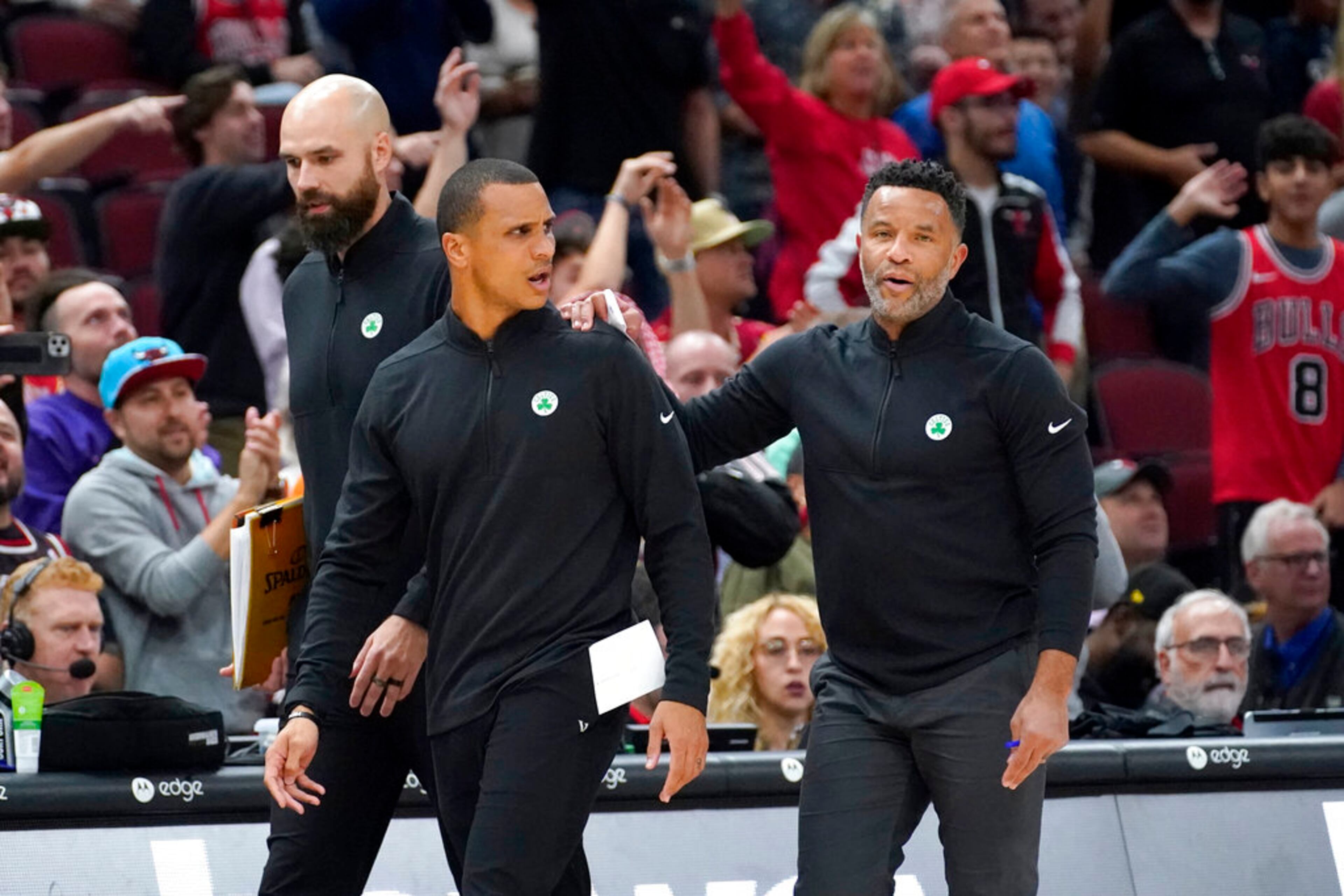 Boston Celtics interim head coach Joe Mazzulla, center, walks off the court with assistants Ben Sullivan, left, and Damon Stoudamire after Mazzulla was ejected in the second half of an NBA basketball game against the Chicago Bulls Monday, Oct. 24, 2022, in Chicago. The Bulls won 120-102. (AP Photo/Charles Rex Arbogast)
