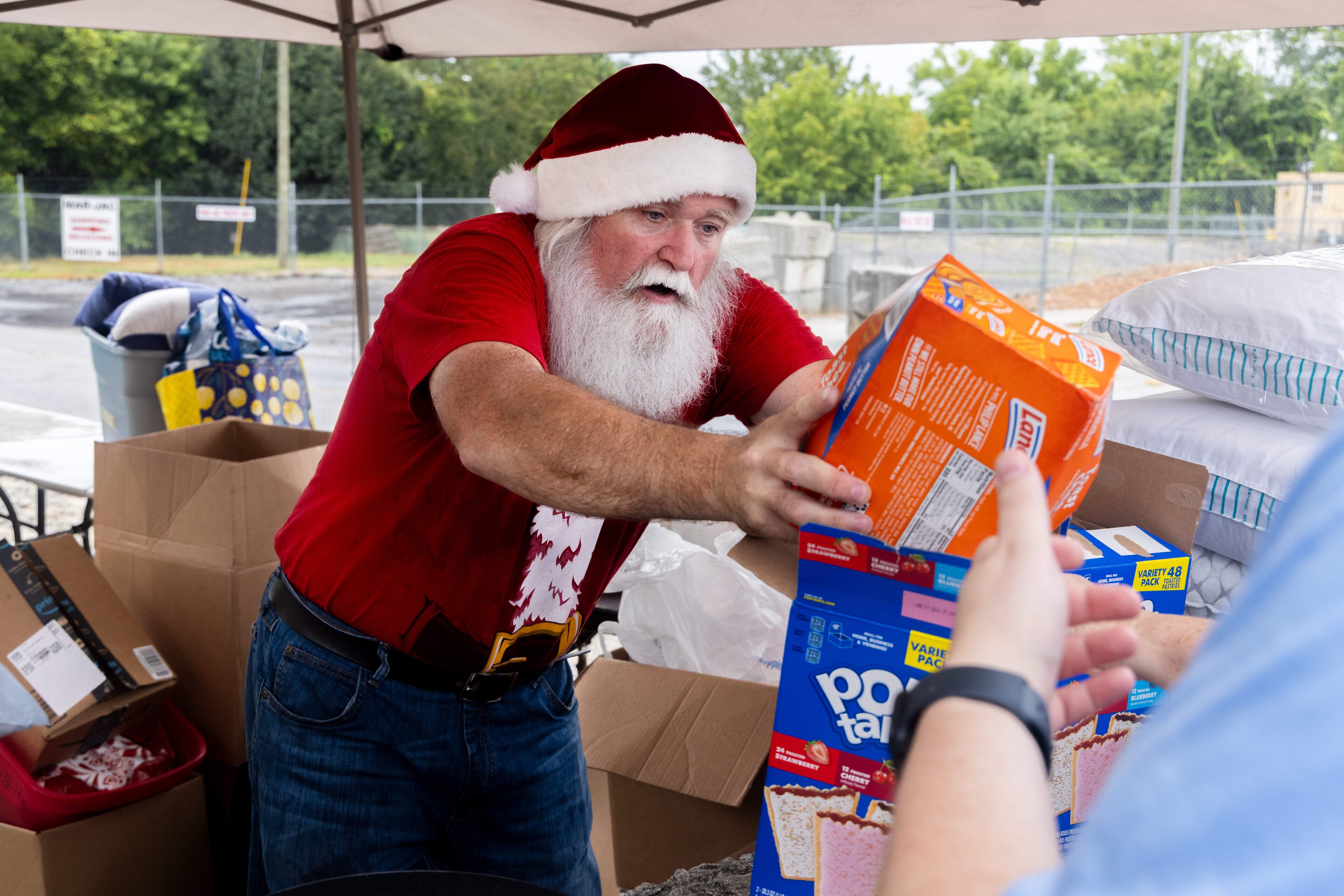 Randy Smith leads a group of volunteers from Santa for the Homeless. The group comprised of members from 10 different churches provides much needed supplies to the estimated 104 people that live at the Gainesville encampment.