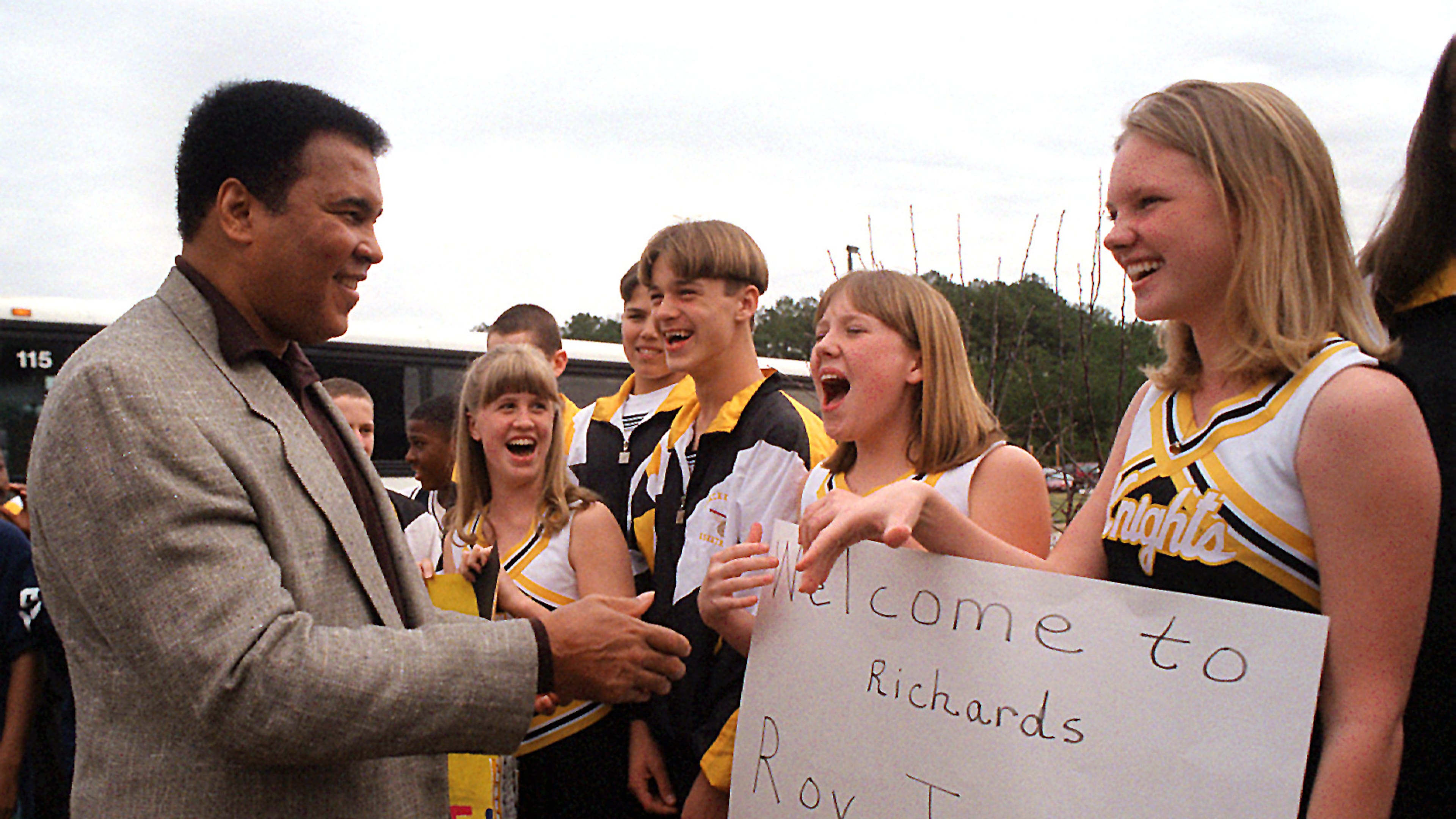 Muhammad Ali is greeted by students at Lawrenceville's Richards Middle School on Feb. 25, 1997. FILE PHOTO