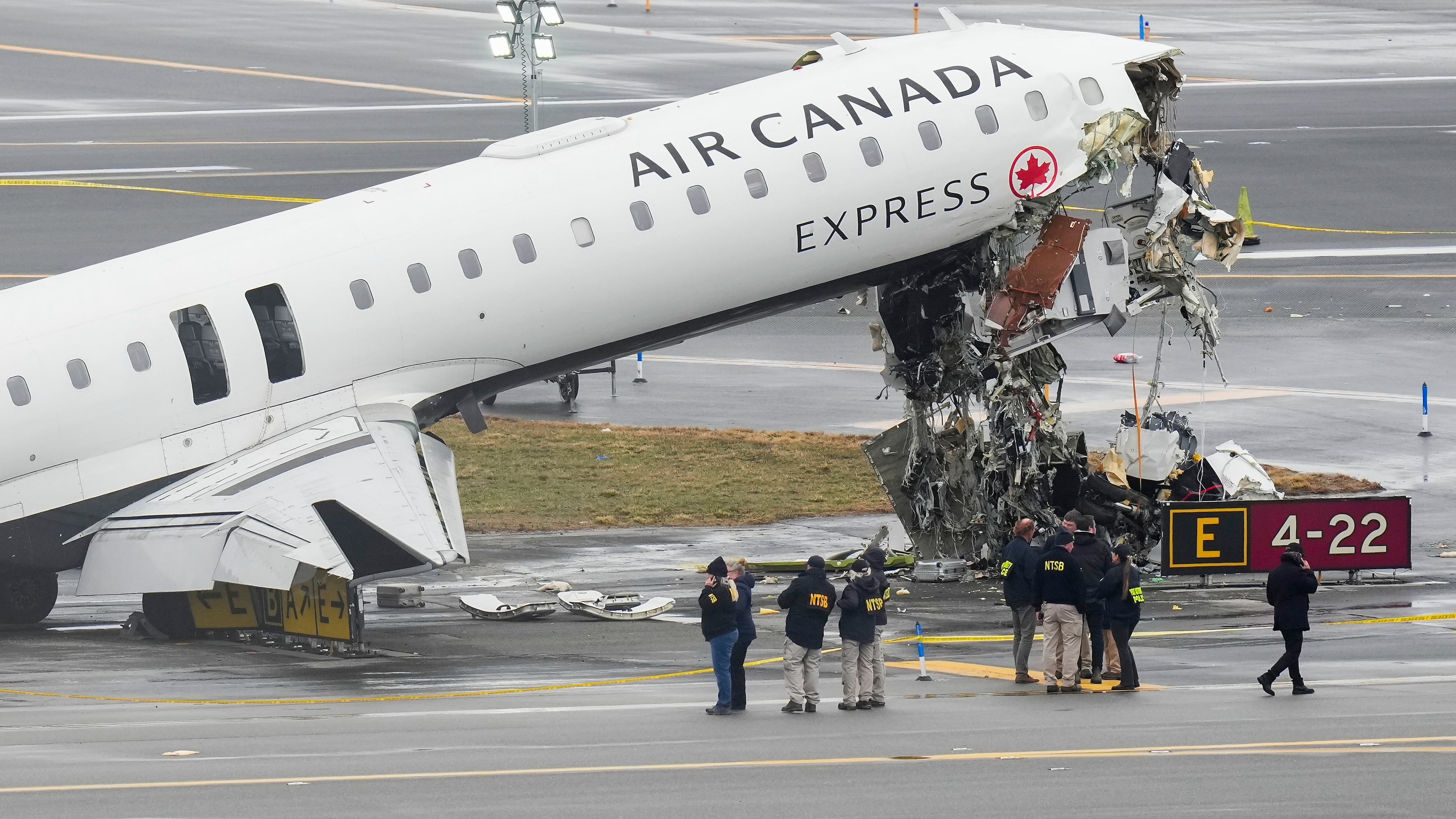 Officials with the National Transportation Safety Board investigate the site, Monday, March 23, 2026, where an Air Canada jet came to rest after colliding with a Port Authority firetruck at LaGuardia Airport, shortly after landing Sunday night in New York. (AP Photo/Seth Wenig)