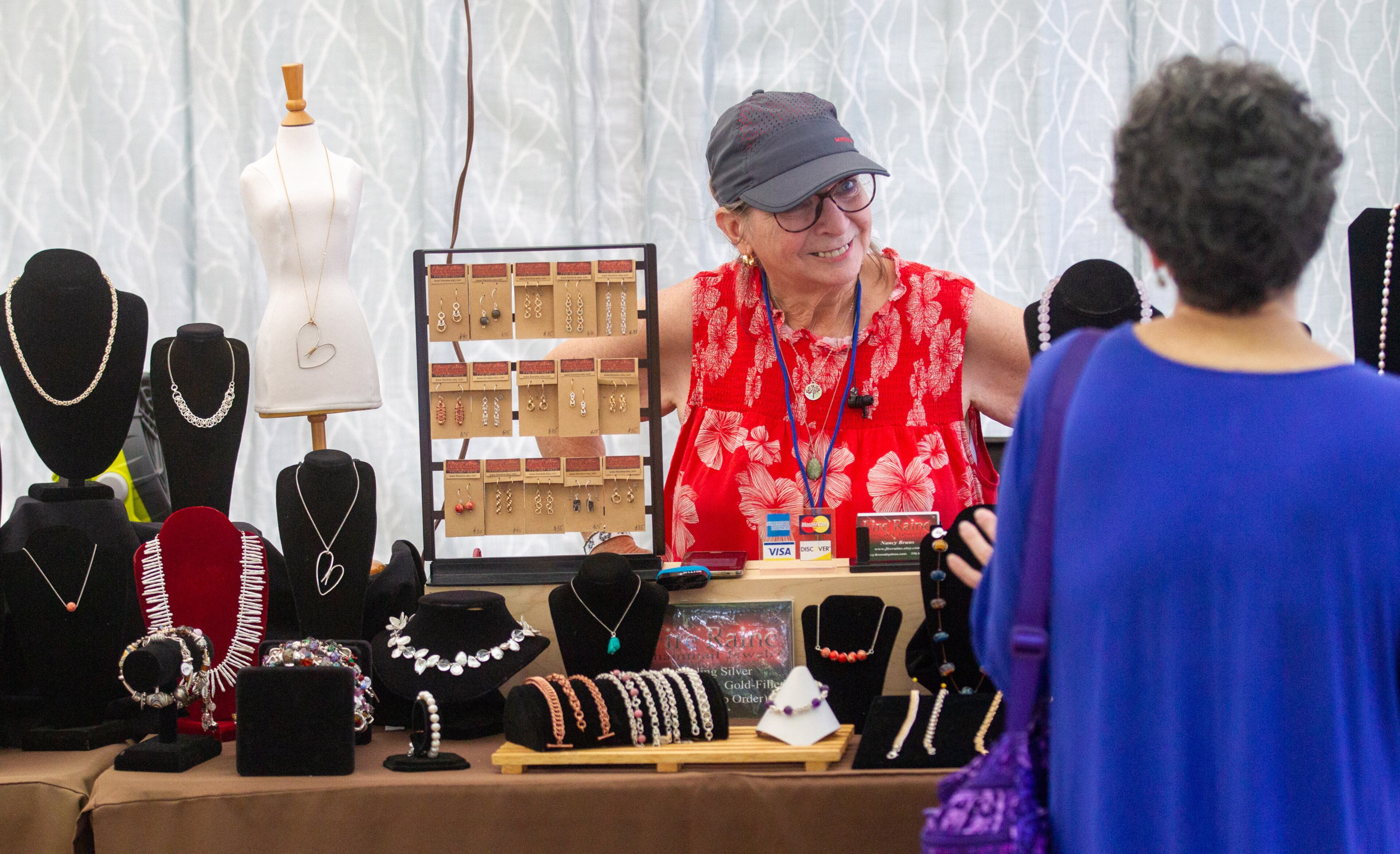 Nancy Burns talks with a customer in her artist tent during the Roswell Spring Arts and Crafts Festival on Sunday, June 13, 2021. (Photo: Steve Schaefer for The Atlanta Journal-Constitution)