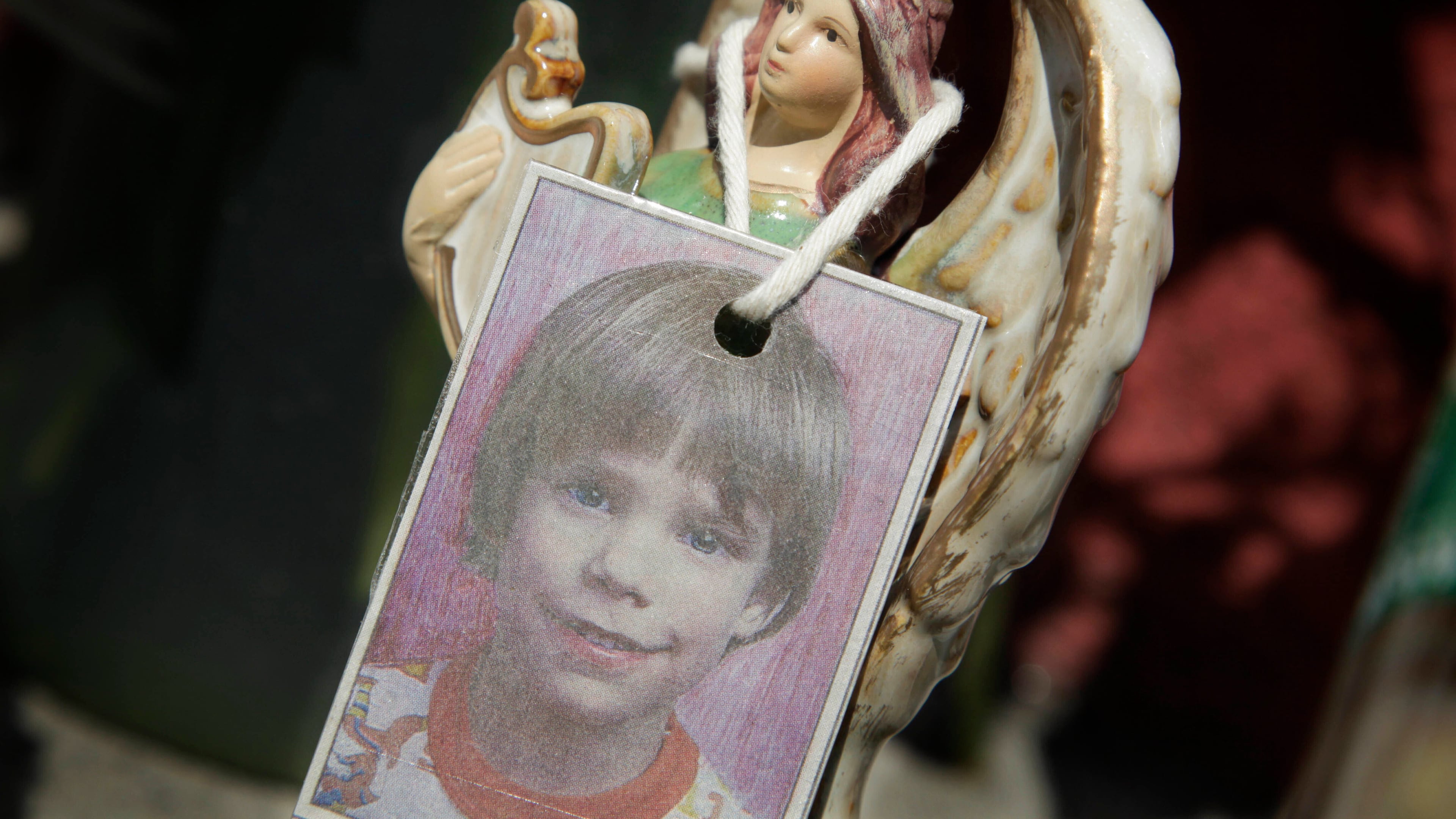 FILE - A photograph of Etan Patz hangs on an angel figurine, as part of a makeshift memorial in New York, May 28, 2012. (AP Photo/Mark Lennihan, File)