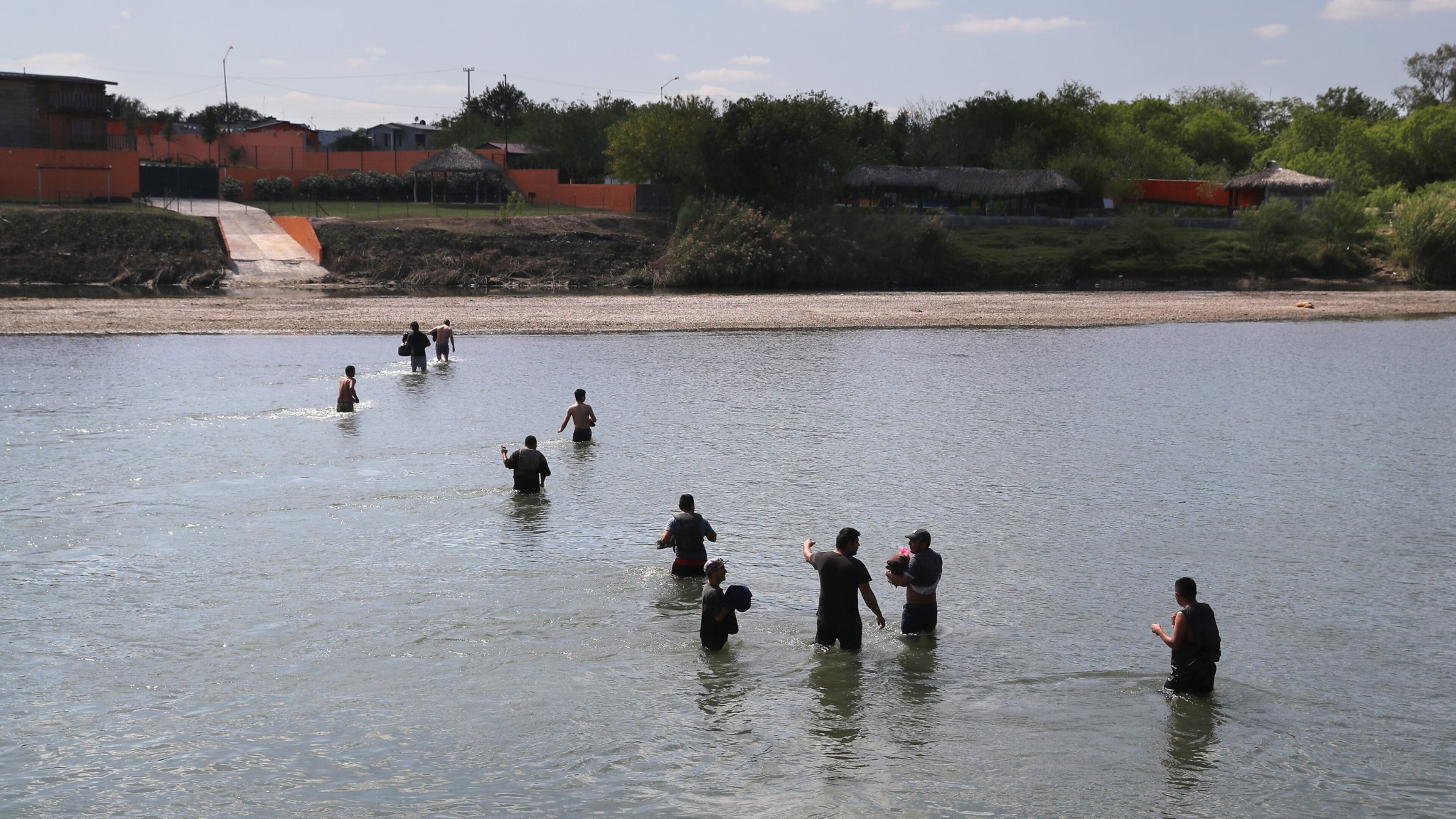 ROMA, TX : A group of undocumented immigrants wade across the Rio Grande River at the U.S.-Mexico border on March 14, after being turned back by U.S. Border Patrol agents. (Photo by John Moore/Getty Images)