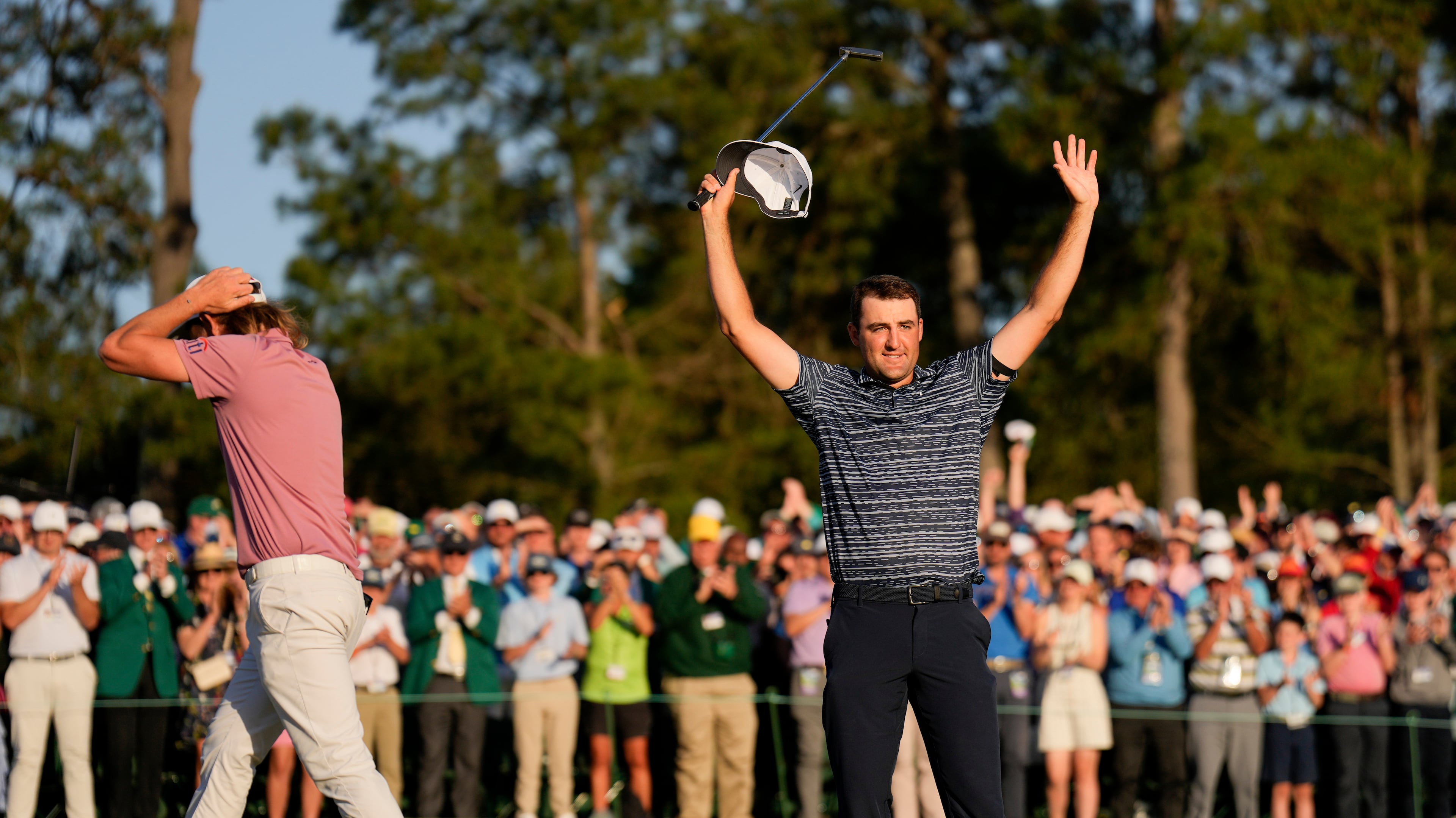 FILE - Cameron Smith, of Australia, walks past as Scottie Scheffler celebrates after winning the 86th Masters golf tournament on April 10, 2022, in Augusta, Ga. (AP Photo/Matt Slocum, File)