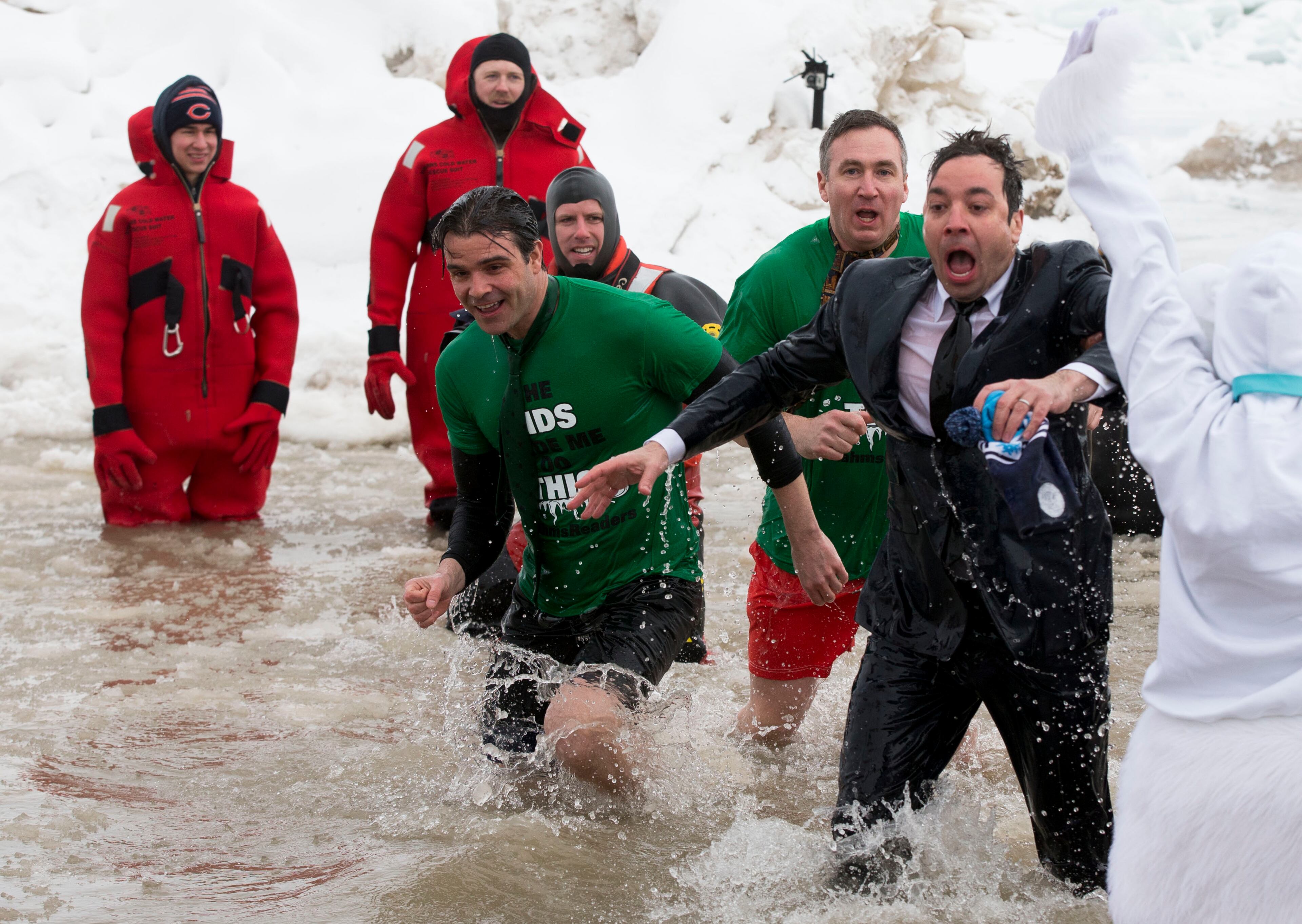 "The Tonight Show" host Jimmy Fallon, right, exits the water during the Chicago Polar Plunge, Sunday, March 2, 2014, in Chicago. It was 10 degrees during the plunge, according to Associated Press writer Kerry Lester, and Chicago firefighters in red wetsuits waded in before the waves of brave souls, throwing chunks of ice out of the area. (AP Photo/Andrew A. Nelles)