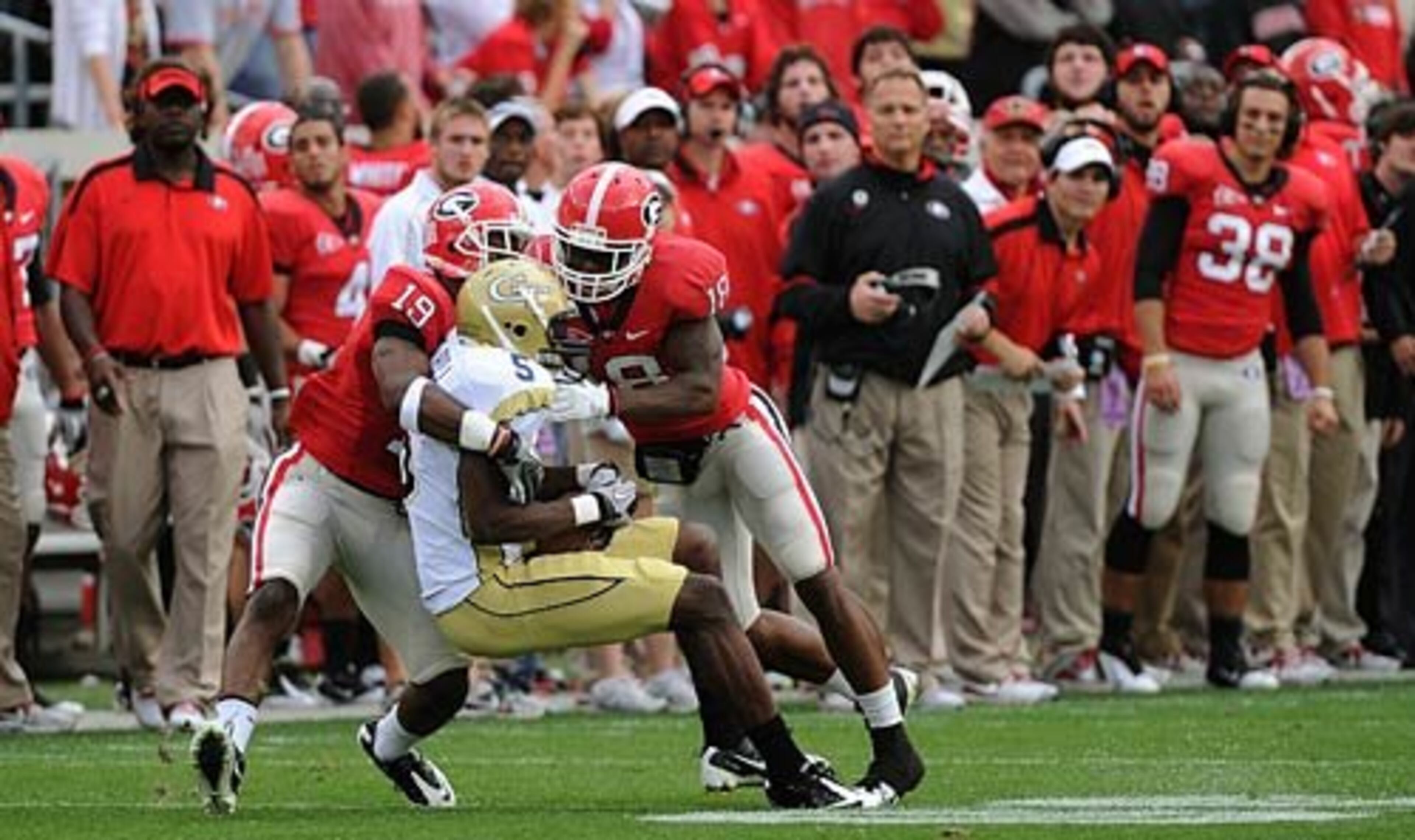 Georgia Tech's Stephen Hill (5) is tackled in the final minutes of the fourth quarter by UGA's Bacarri Rambo (18) and Sanders Commings (19).