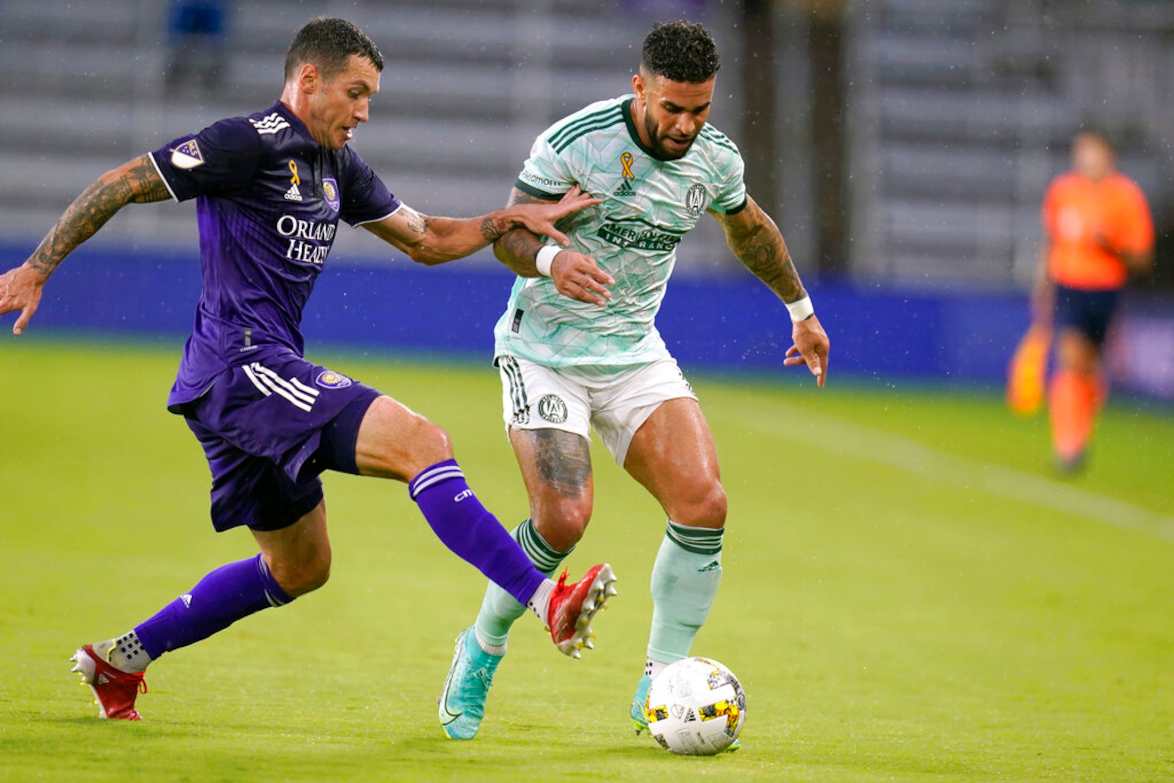 Orlando City's Kyle Smith, left, makes a move in front of Atlanta United's Dom Dwyer during the first half of an MLS soccer match Wednesday, Sept. 14, 2022, in Orlando, Fla. (AP Photo/John Raoux)