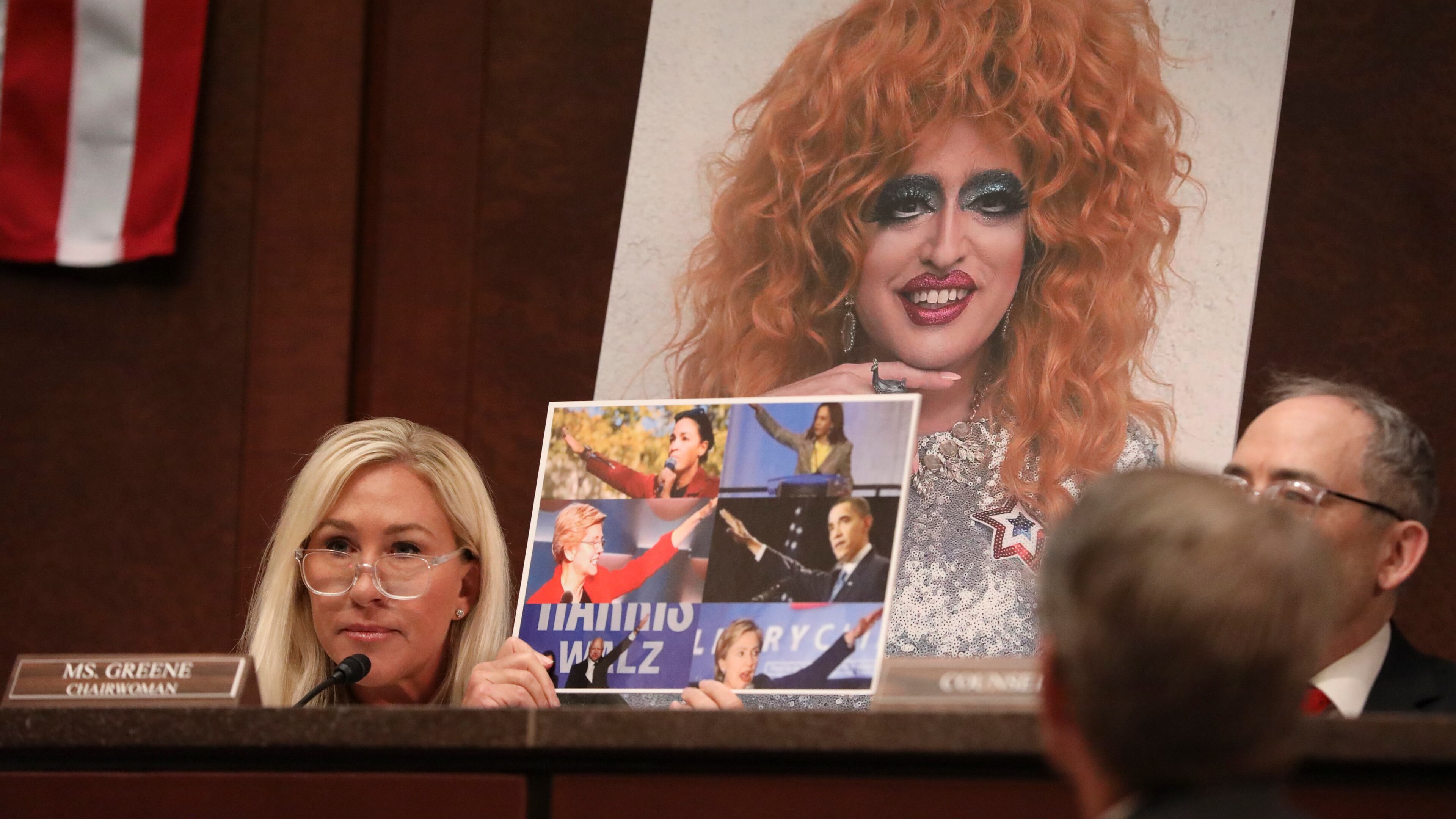 Rep. Marjorie Taylor Greene (R-Ga.) holds up an image of Democrats with their arms raised during a hearing of the House Committee on Oversight and Government Reform subcommittee on Delivering Government Efficiency on Capitol Hill in Washington, on Wednesday, March 26, 2025. (Anna Rose Layden/The New York Times)