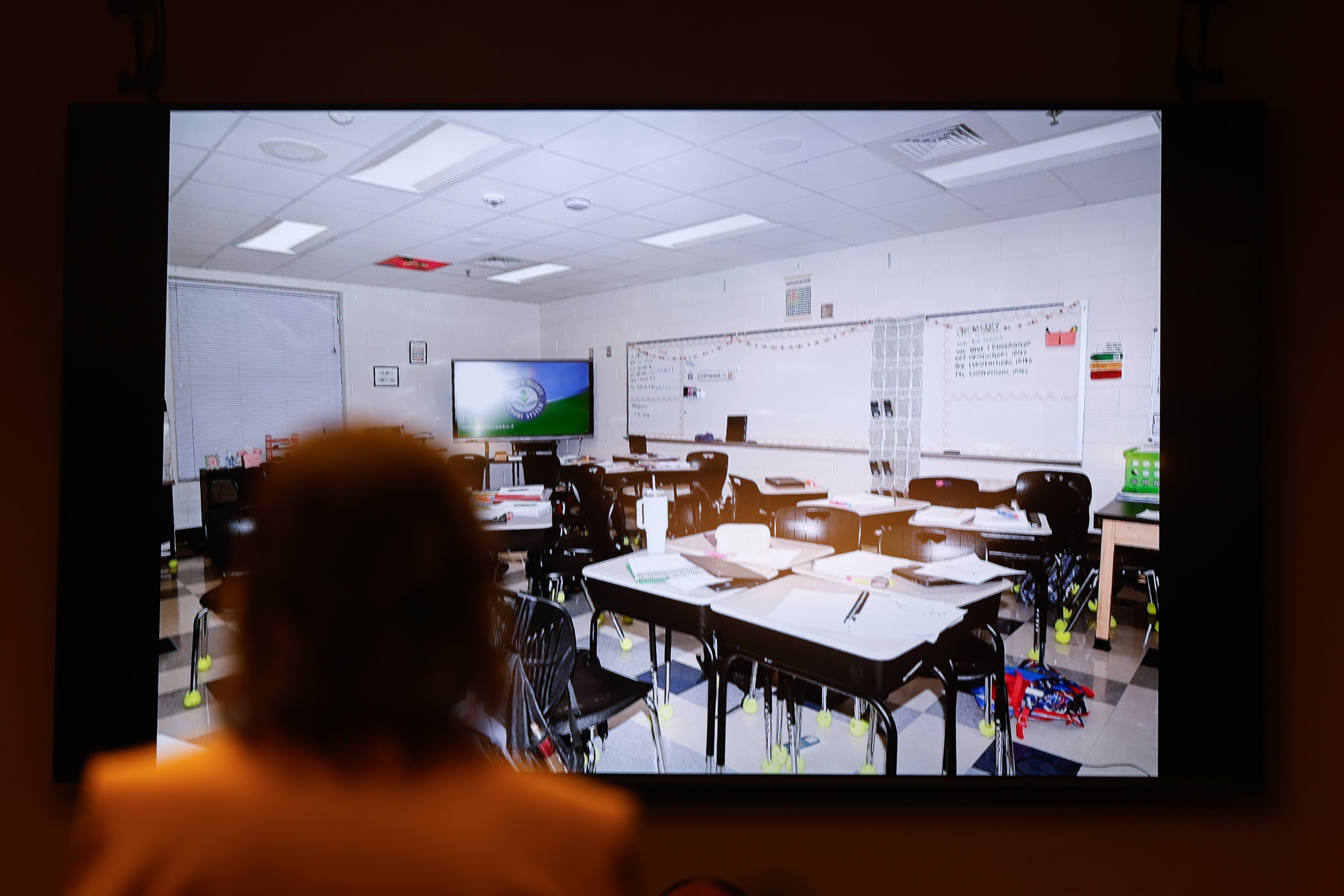 A screen displays a crime scene photo of the high school classroom of Colt Gray, the 16-year-old Apalachee High School shooting suspect, at Barrow County Superior Court in Winder on July 24, 2026. Four people died and nine were injured at the school shooting in Barrow County on Sept. 4, 2024. (Arvin Temkar/AJC)