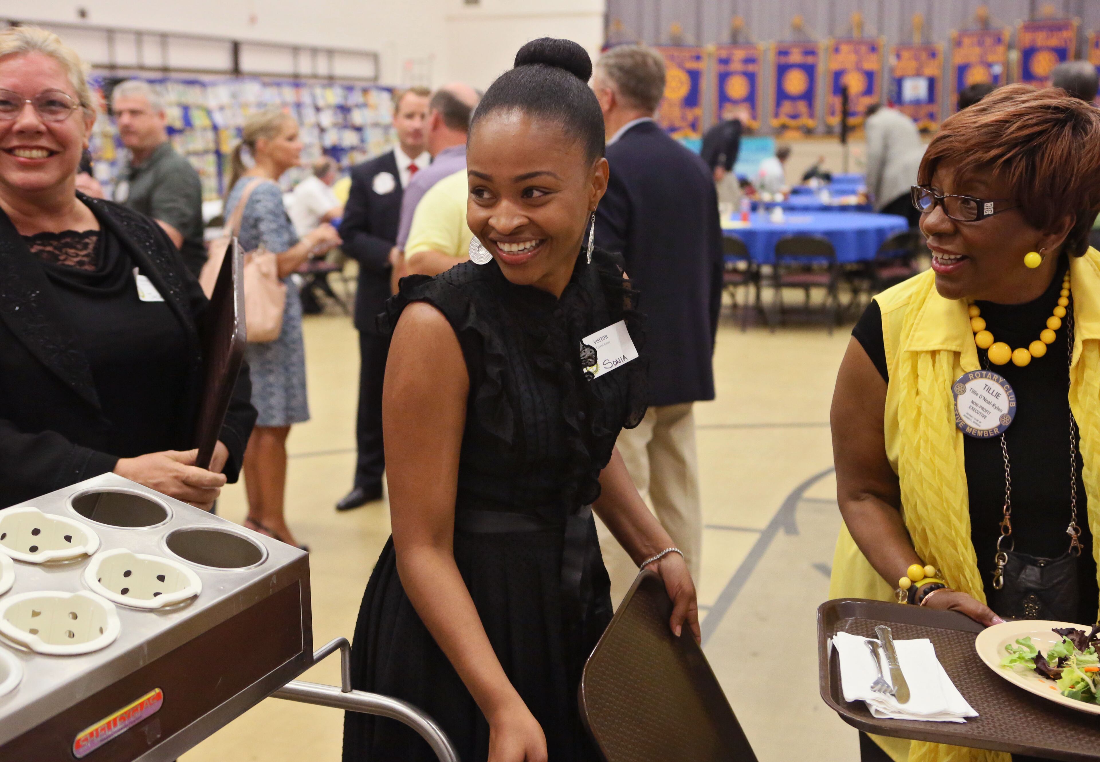 Simon (center) goes through the lunch line with Tillie O'Neal-Kyles (right), founder of Every Woman Works, before a Roswell Rotary Club meeting. Simon spoke to the group about her struggles adapting to civilian life after serving in Iraq and how Every Woman Works helped her stabilize her life.