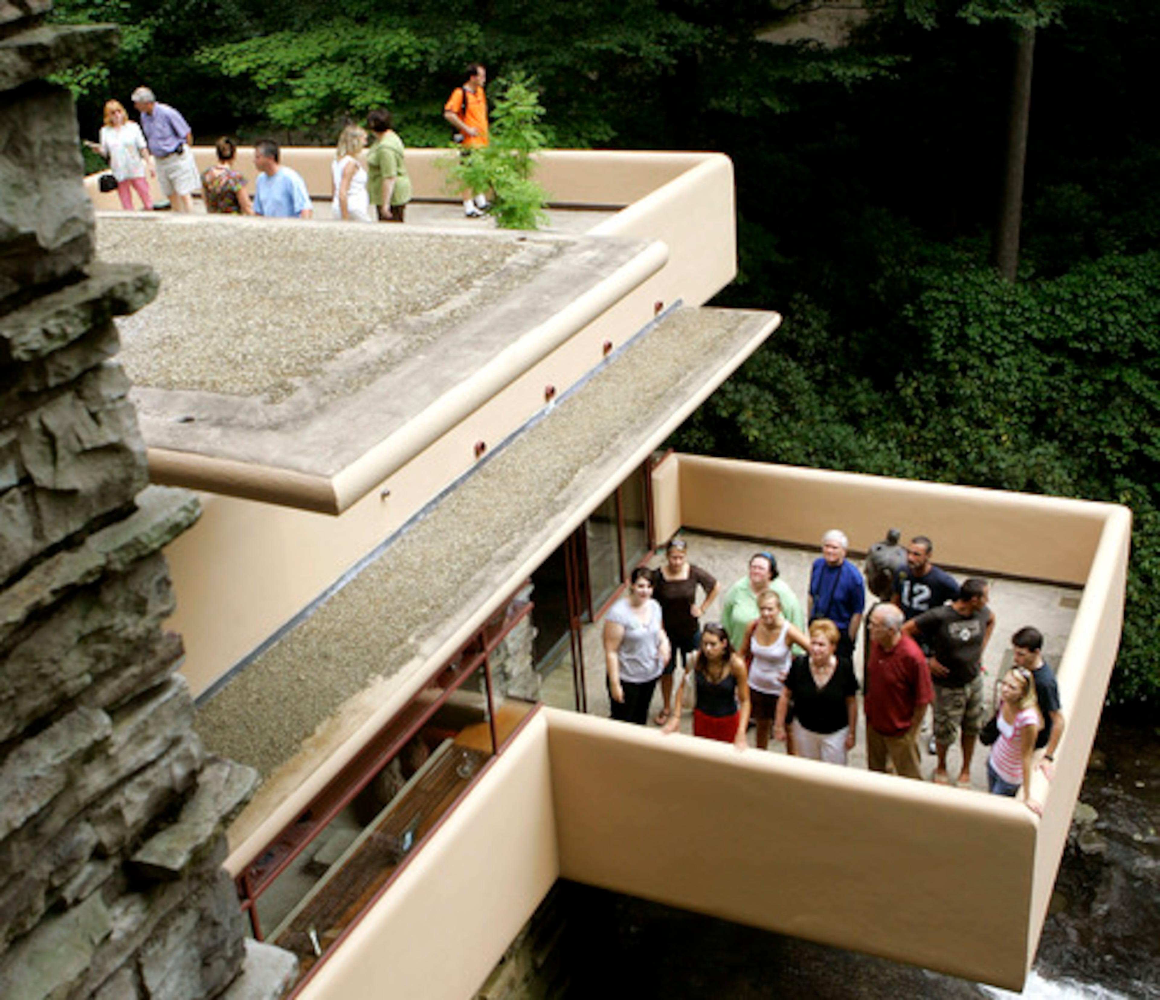 Visitors to Fallingwater listen to tour guides as they stand on the concrete terraces. Fallingwater gets more than 120,000 visitors annually.