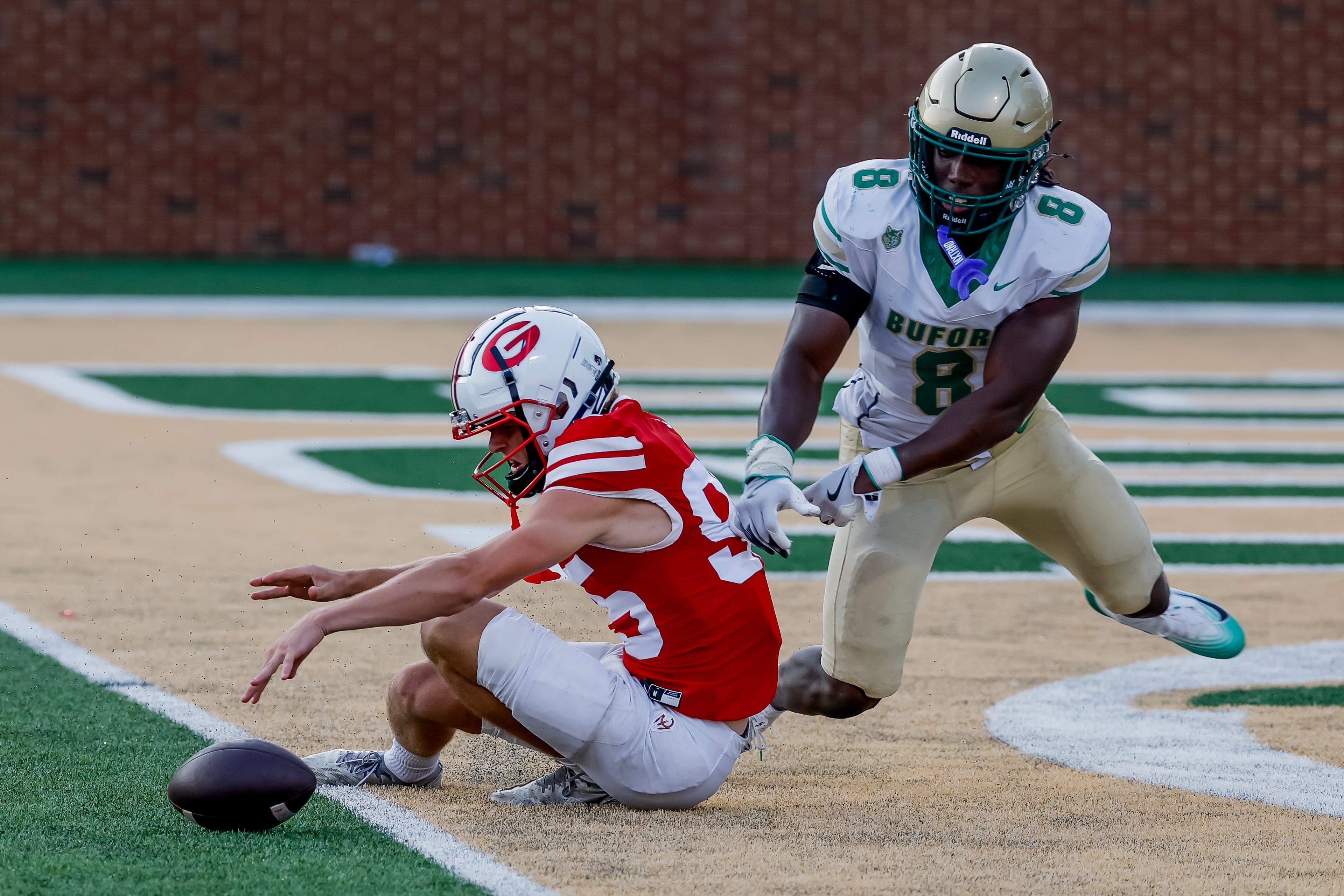 Gainesville punter Logan Gailey (95) fumbles the snap at the end zone against Joshua Echols (8) during the second half of a high school football game between Buford and Gainesville, Saturday, Aug. 22, 2026, in Buford, GA. (Erik S. Lesser for the AJC)