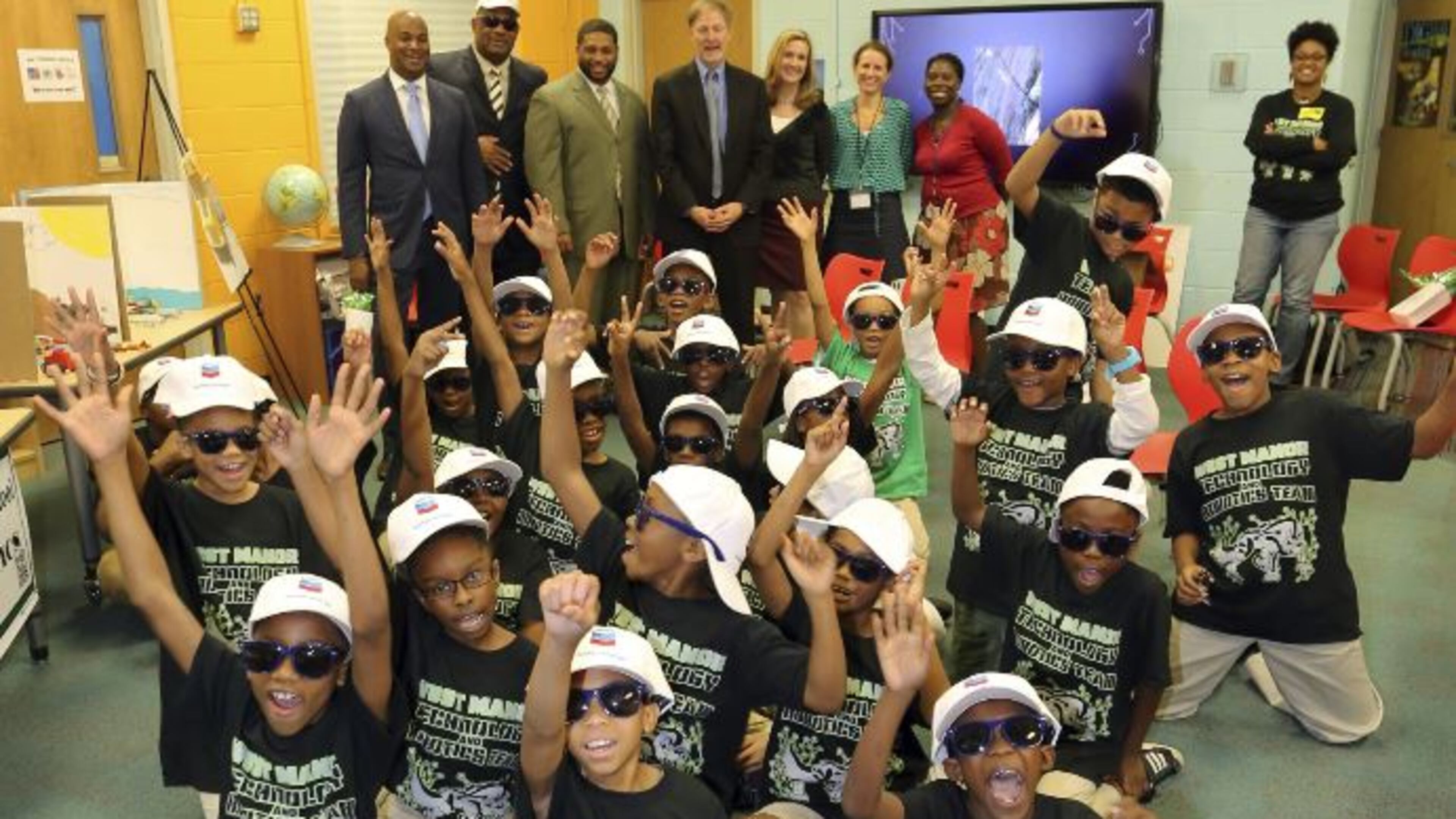 From left: Councilman Kwanza Hall, Steven Lee (Board of Education), Dr. Reginald Lawrence (West Manor Elementary School Principal), Jeff Swindel (Chevron), Lara Sweeny (Chevron), Katie McDowell (APS), and Kenita Williams (APS) with Carla Anderson’s West Manor Robotics Team.