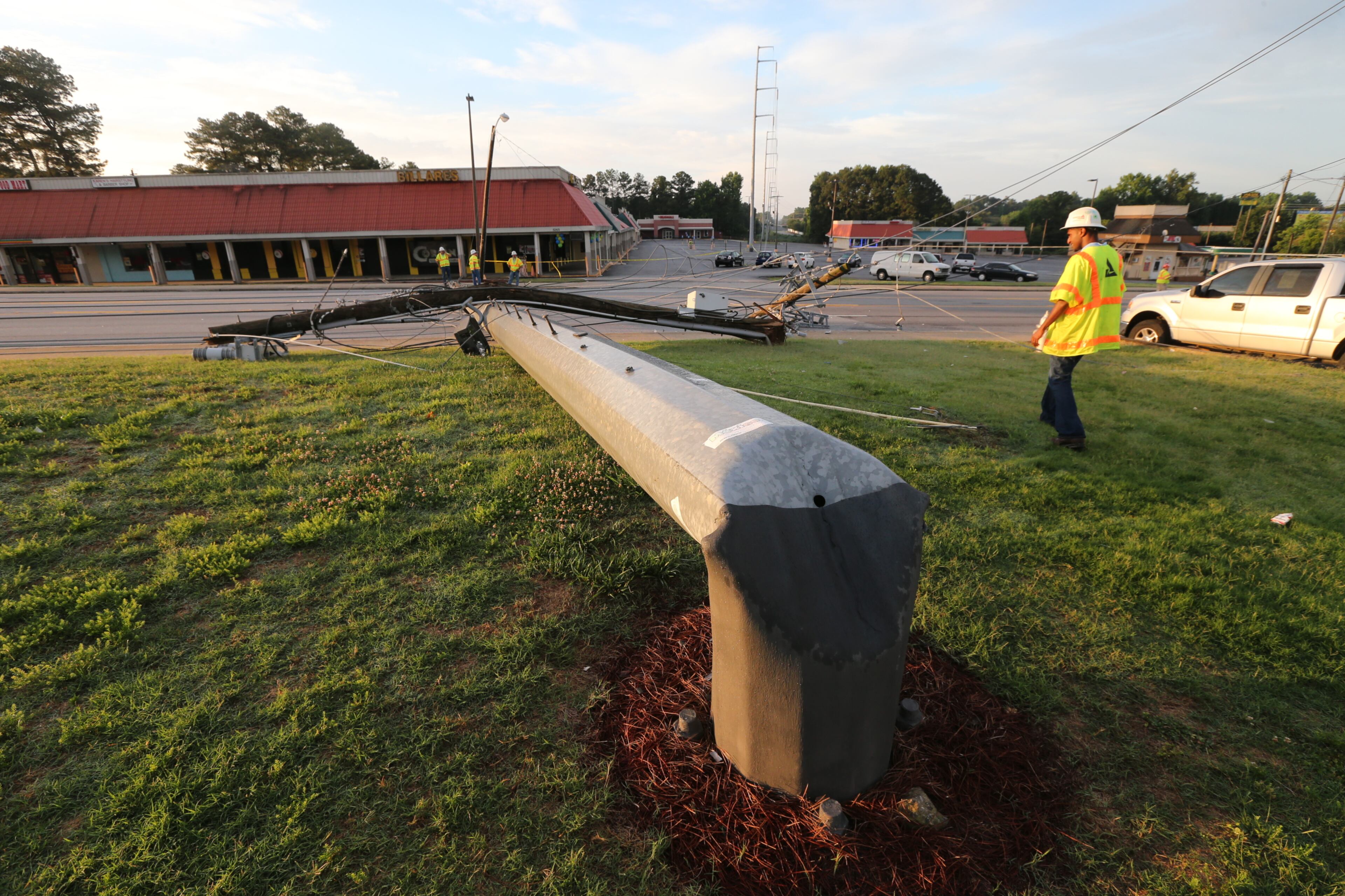 A second pole also fell onto a nearby grassy area. It was not immediately clear what caused the poles to topple. JOHN SPINK/JSPINK@AJC.COM