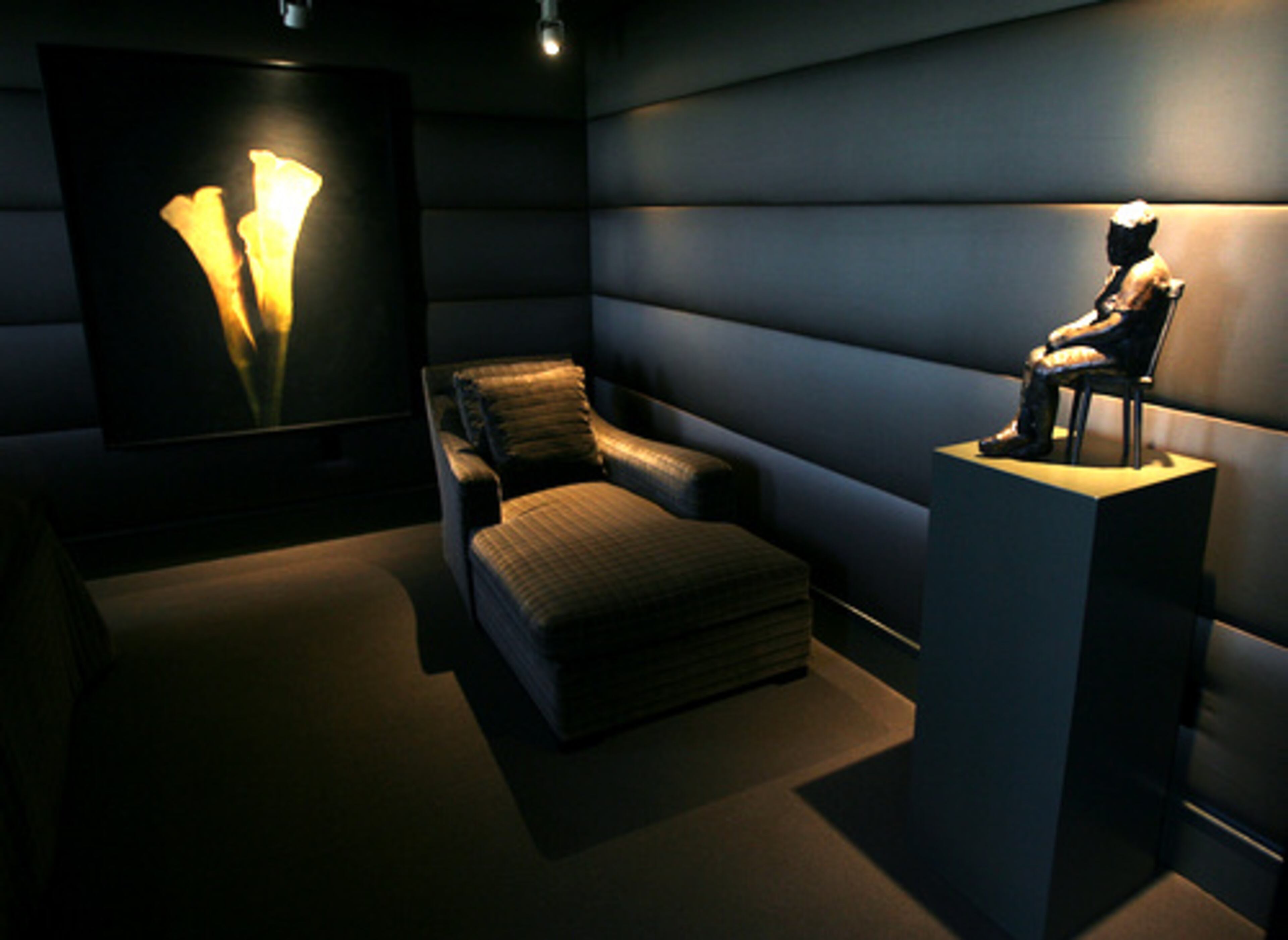 Track lighting illuminates some of the many pieces of art in the master bedroom, which also includes artwork by local painter Maggie Hasbrouck.