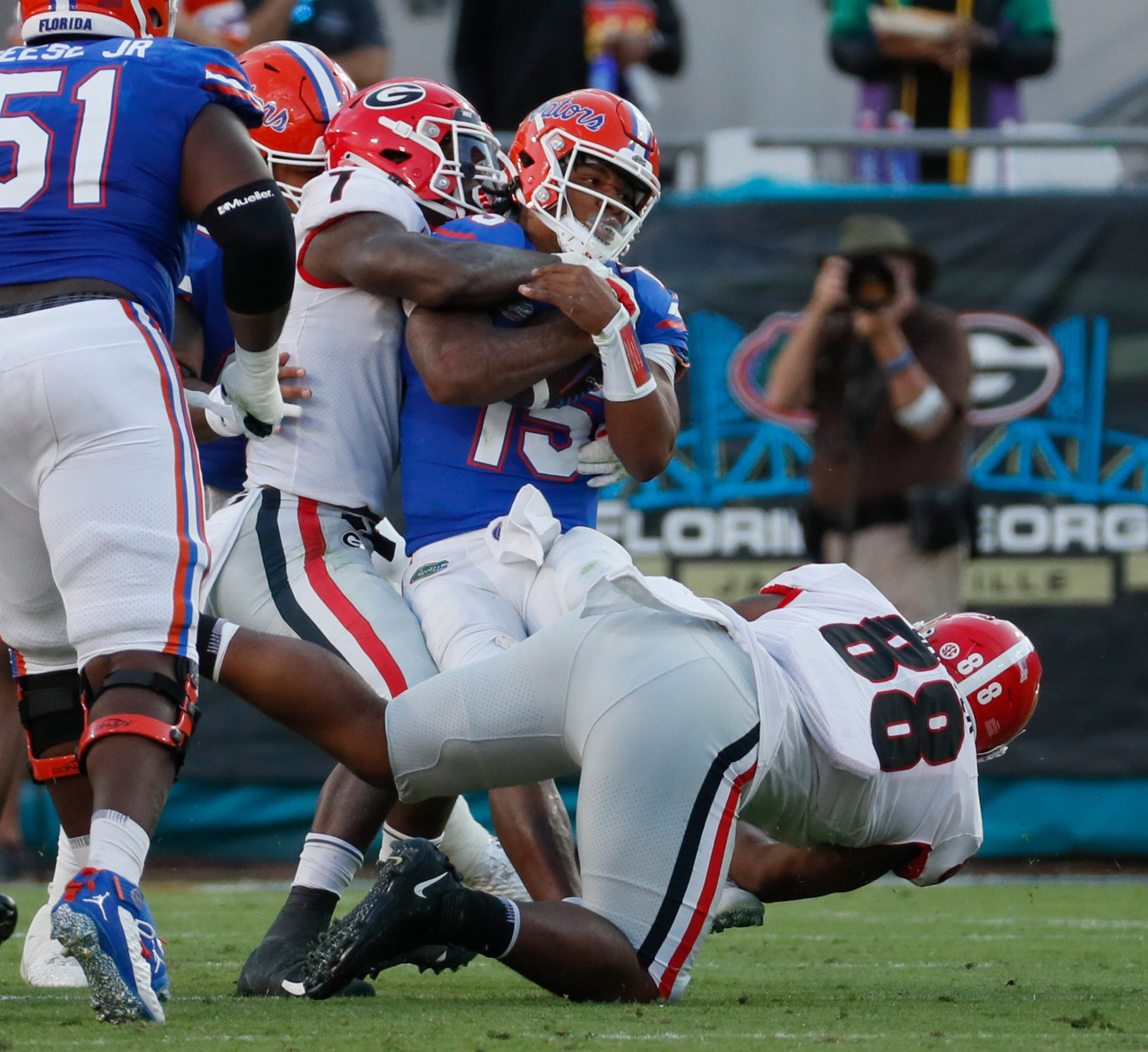 10/30/21 - Jacksonville - Florida Gators quarterback Anthony Richardson (15) is stopped by Georgia Bulldogs linebacker Quay Walker (7) and Georgia Bulldogs defensive lineman Jalen Carter (88) during the second half of the annual NCCA Georgia vs Florida game at TIAA Bank Field in Jacksonville. Georgia won 34-7. Bob Andres / bandres@ajc.com