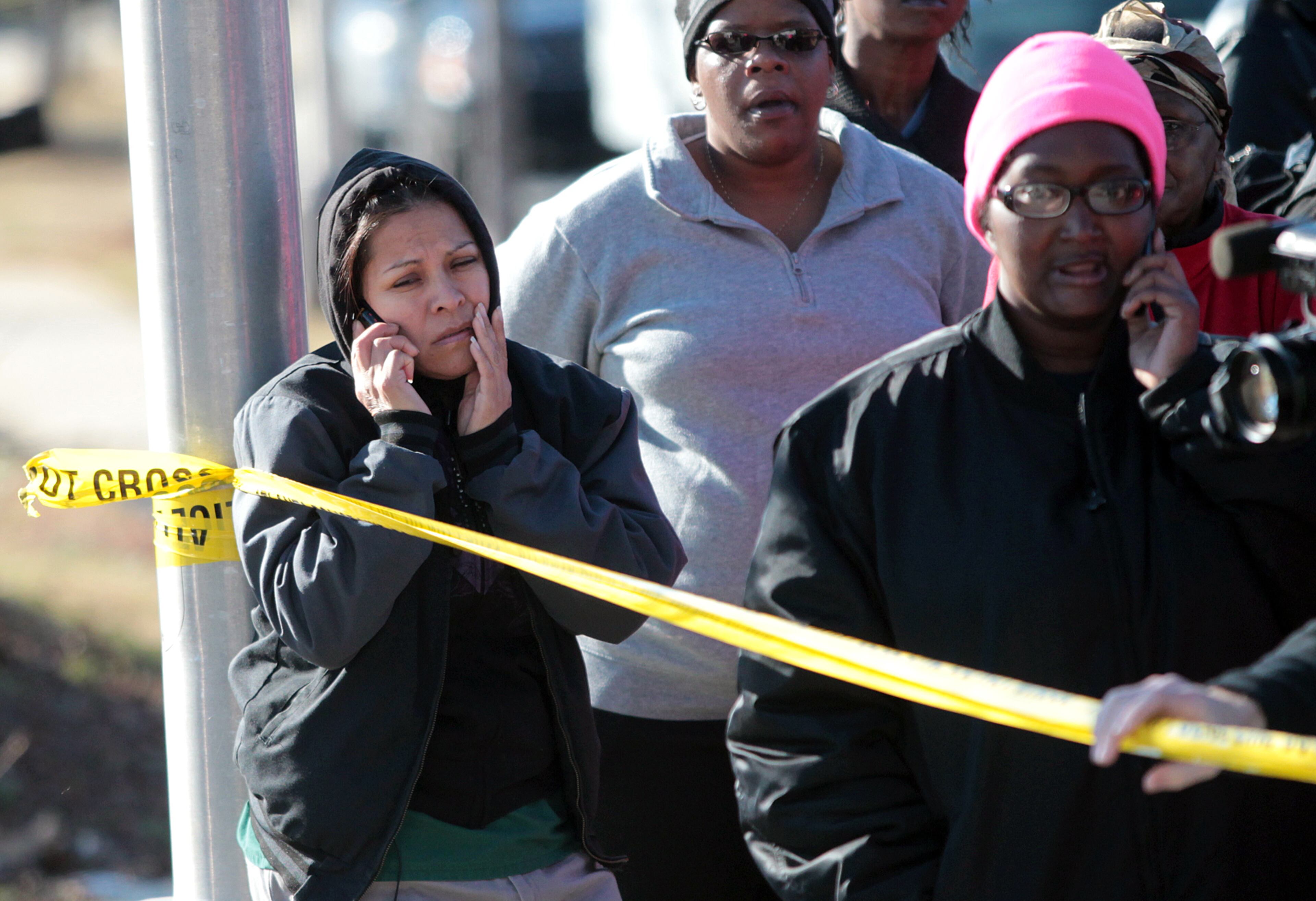 Among the anxious parents, Maria Torres (left) waited for word on her two children, Moises Raphael and Eric Raphael, at a police line outside Price Middle School, where the shooting took place.