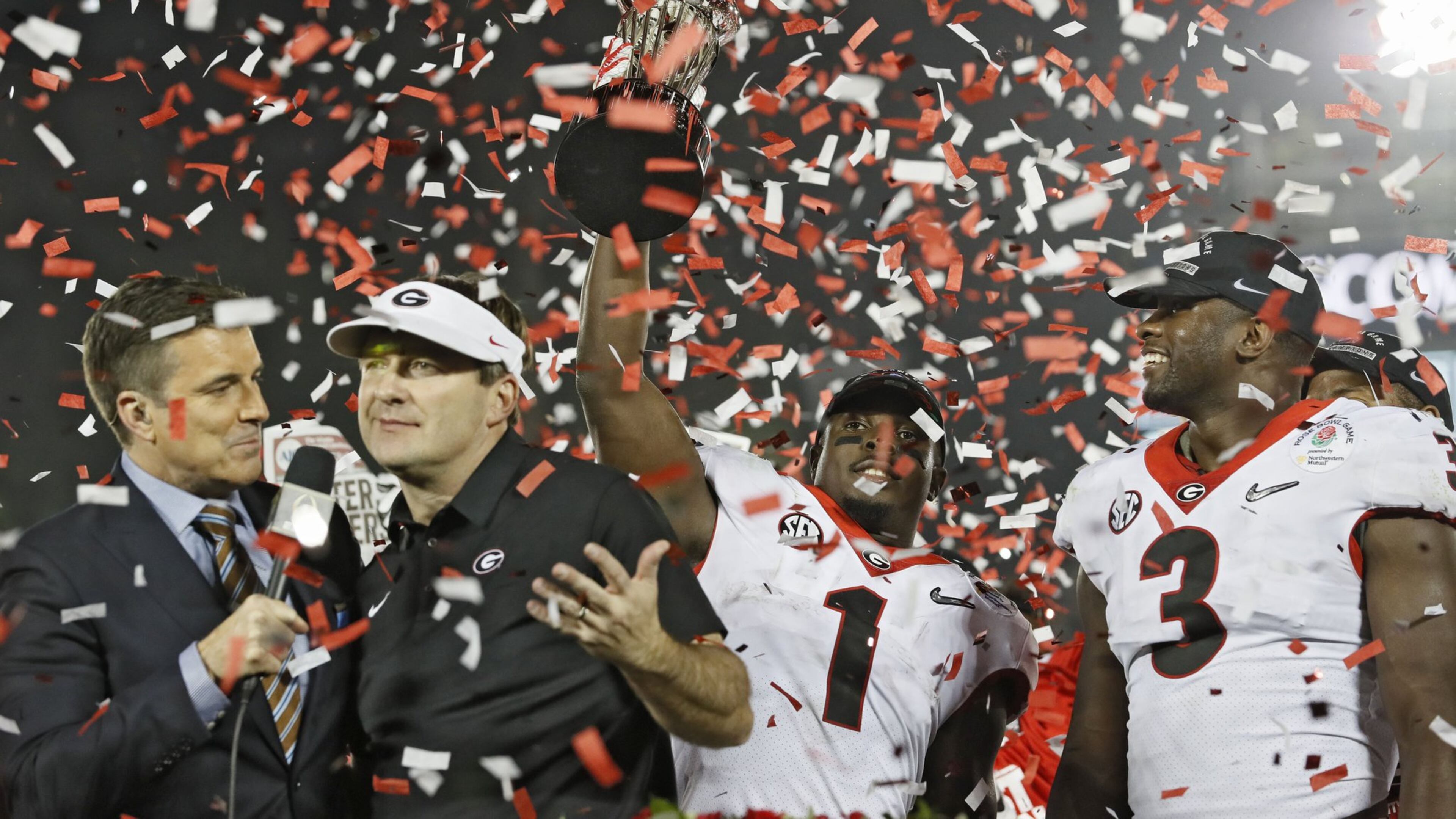 Georgia Bulldogs running back Sony Michel (1) holds the Rose Bowl trophy next to Georgia Bulldogs linebacker Roquan Smith (3) and coach Kirby Smart after the College Football Playoff Semifinal at the Rose Bowl Game on Jan. 1, 2018, in Pasadena, Calif. BOB ANDRES / BANDRES@AJC.COM