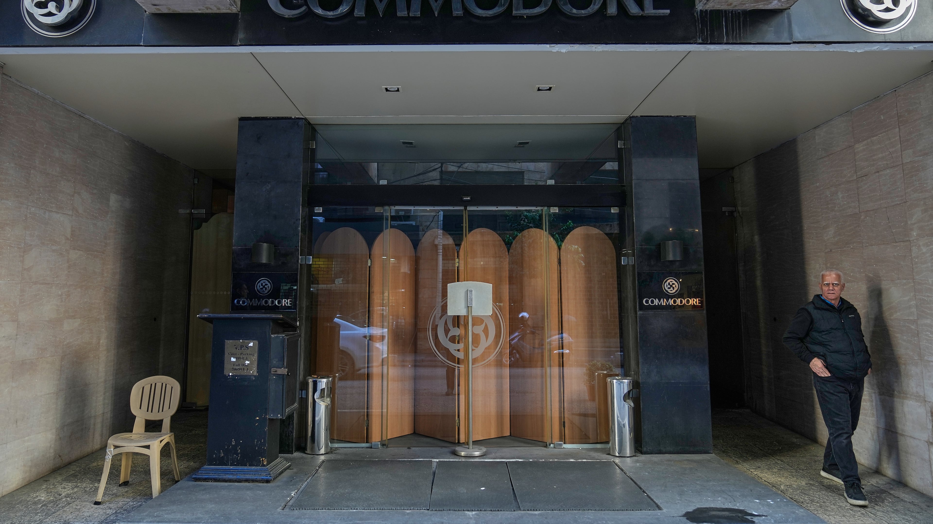 A man stands in the closed main entrance of the Commodore hotel, in Beirut, Lebanon, Sunday, Jan. 11, 2026. (AP Photo/Hussein Malla)
