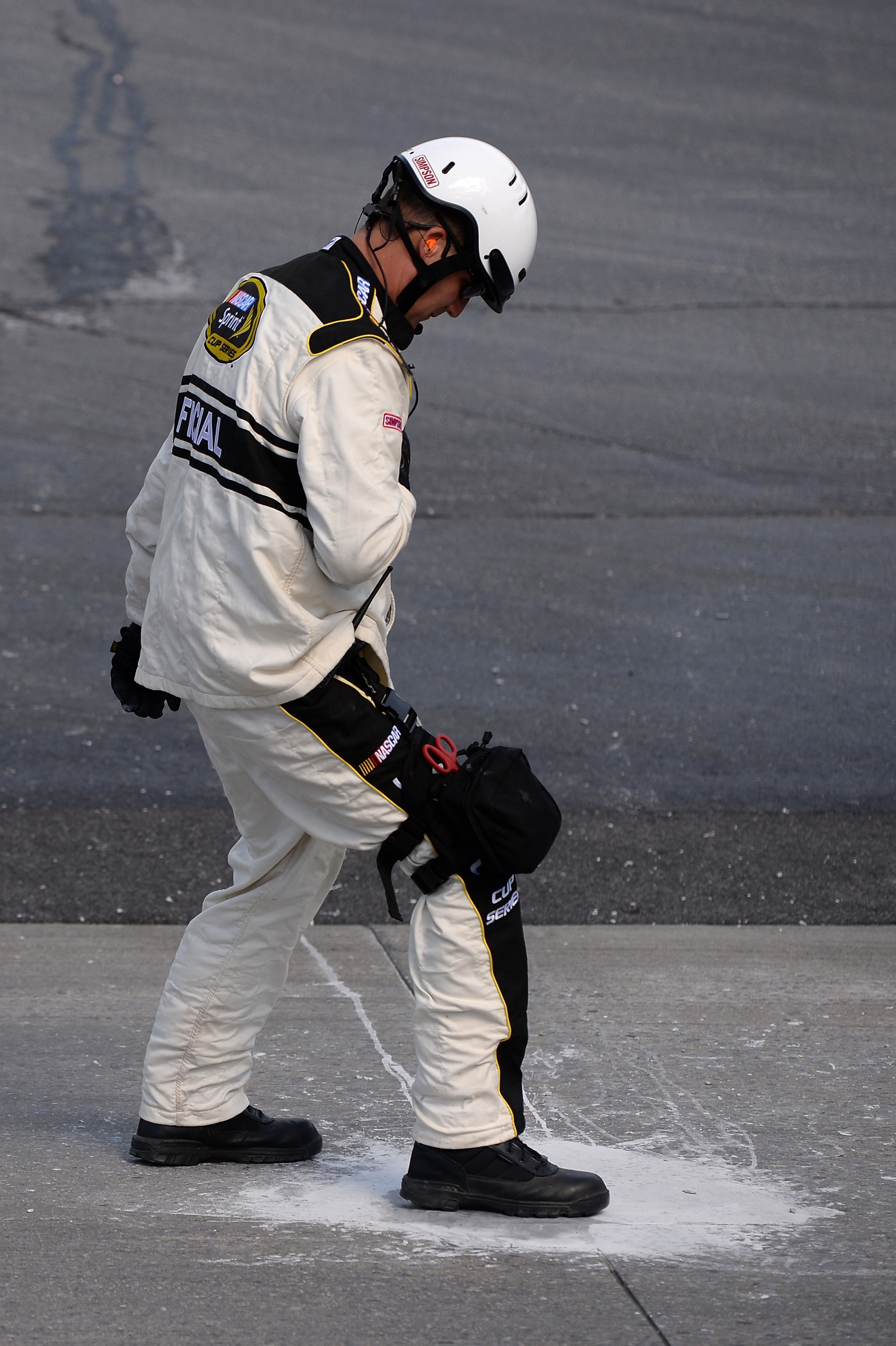 A NASCAR official inspects repairs to the track after a portion of concrete broke loose during the NASCAR Sprint Cup Series FedEx 400 Benefiting Autism Speaks at Dover International Speedway on June 1, 2014 in Dover, Delaware. (Photo by Patrick Smith/Getty Images)