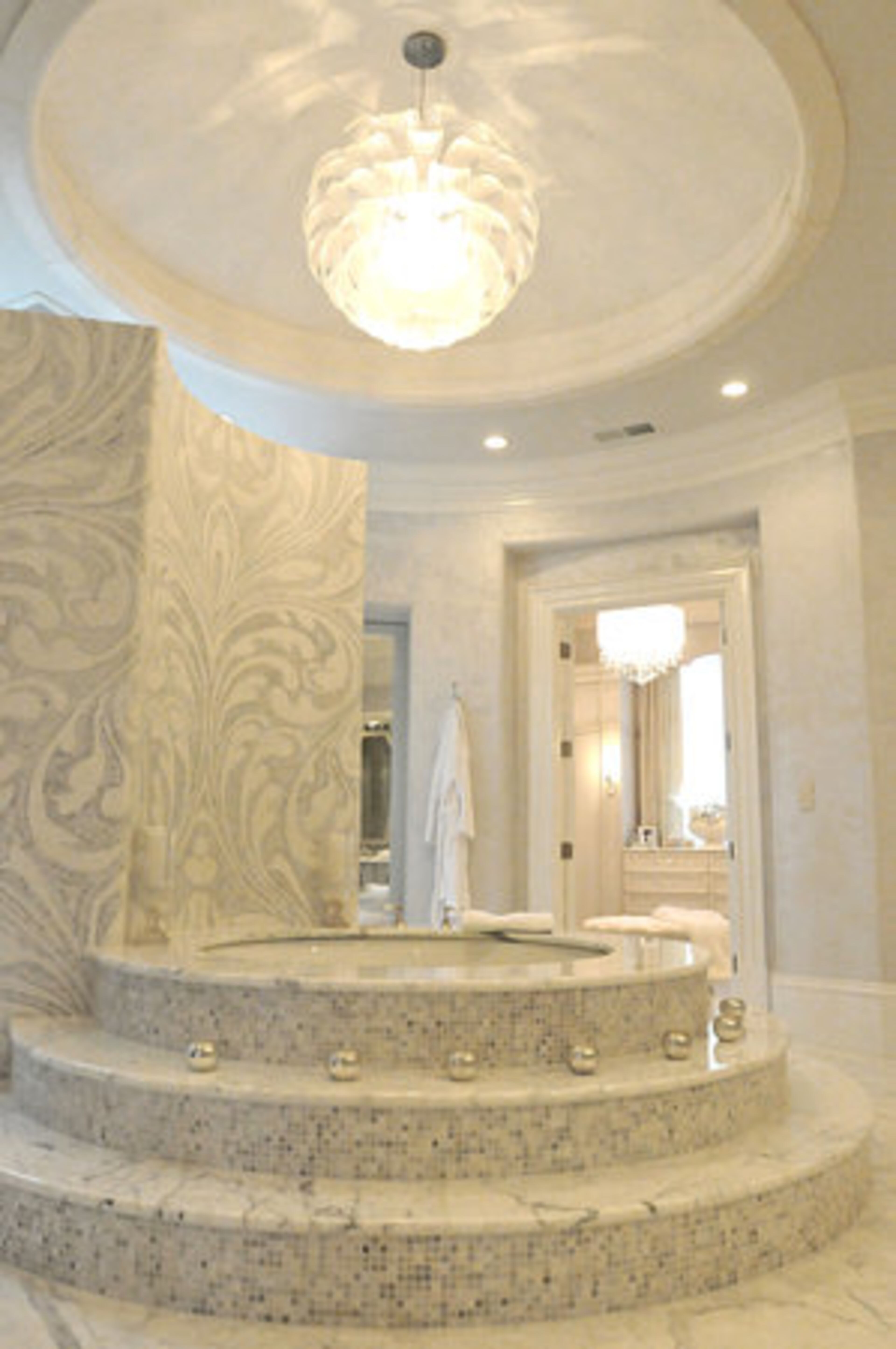 The majestic master bath was designed by Habachy Designs. A soothing spa-like atmosphere is created with the use of statuary marble and artisan mosaic tile work.