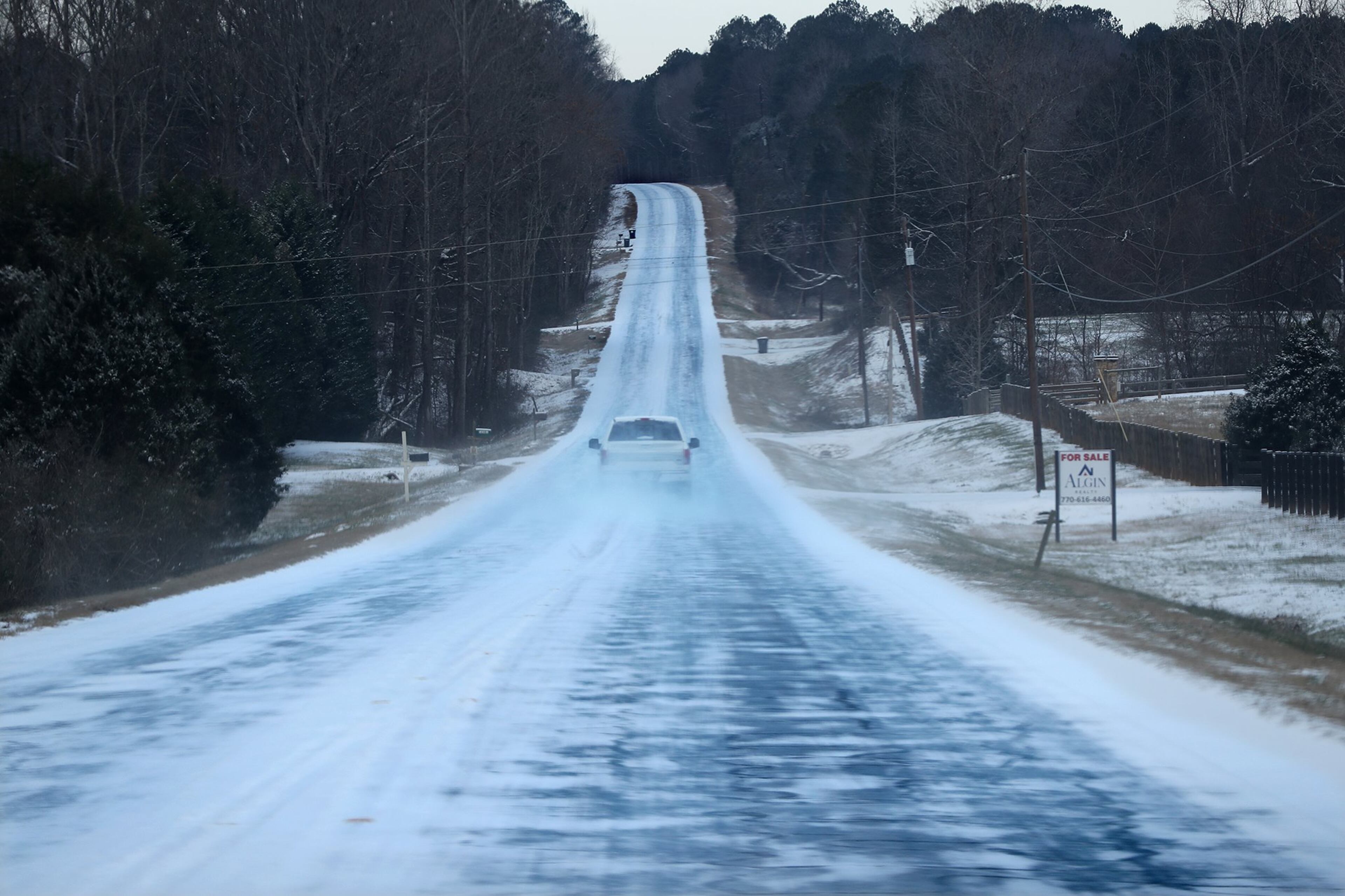 A solitary pickup truck braves the icy conditions driving down the middle of Georgia 142 in Newton County on Wednesday, Jan. 17, 2018, near Newborn. Curtis Compton/ccompton@ajc.com