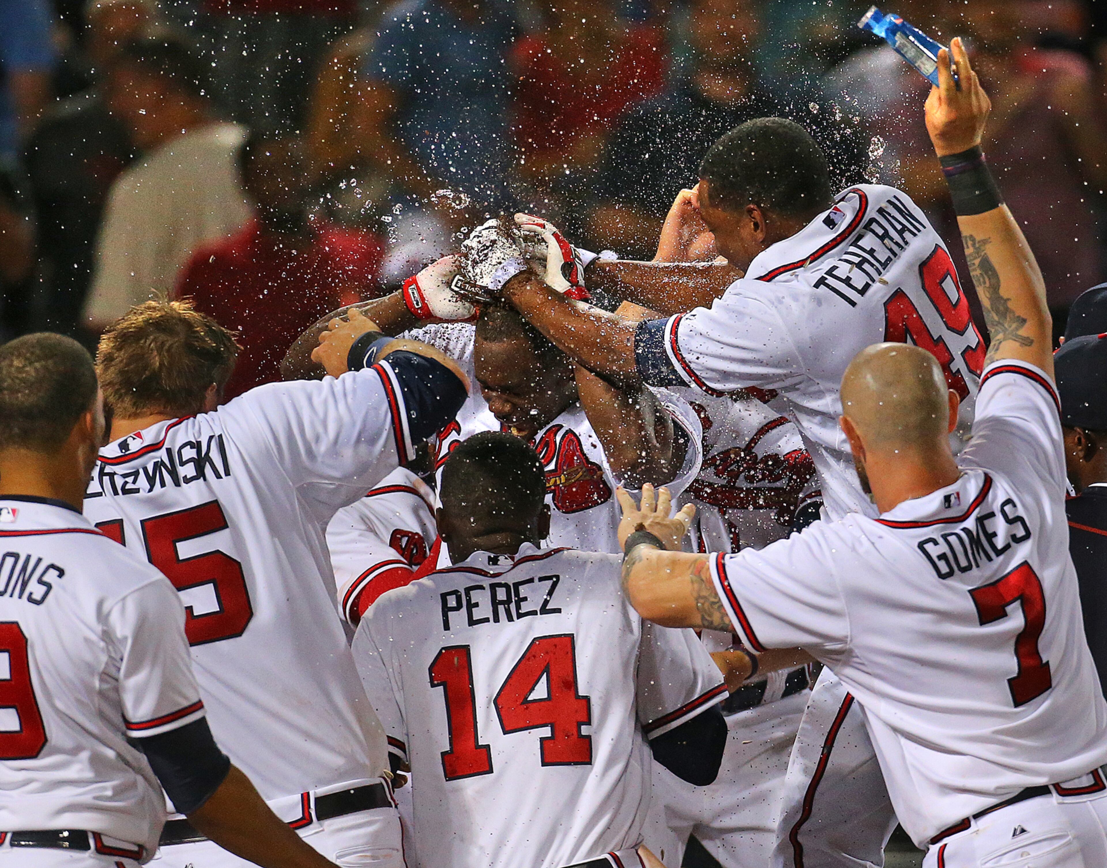 GAME WINNER --080315 ATLANTA Braves Adonis Garcia (center) is covered with dirt by Julio Teheran (right) and sprayed with water at home as he hits a walk off 2-RBI home run to beat the Giants 9-8 in the 12th inning of a baseball game on Monday, August 3, 2015, in Atlanta. Curtis Compton / ccompton@ajc.com