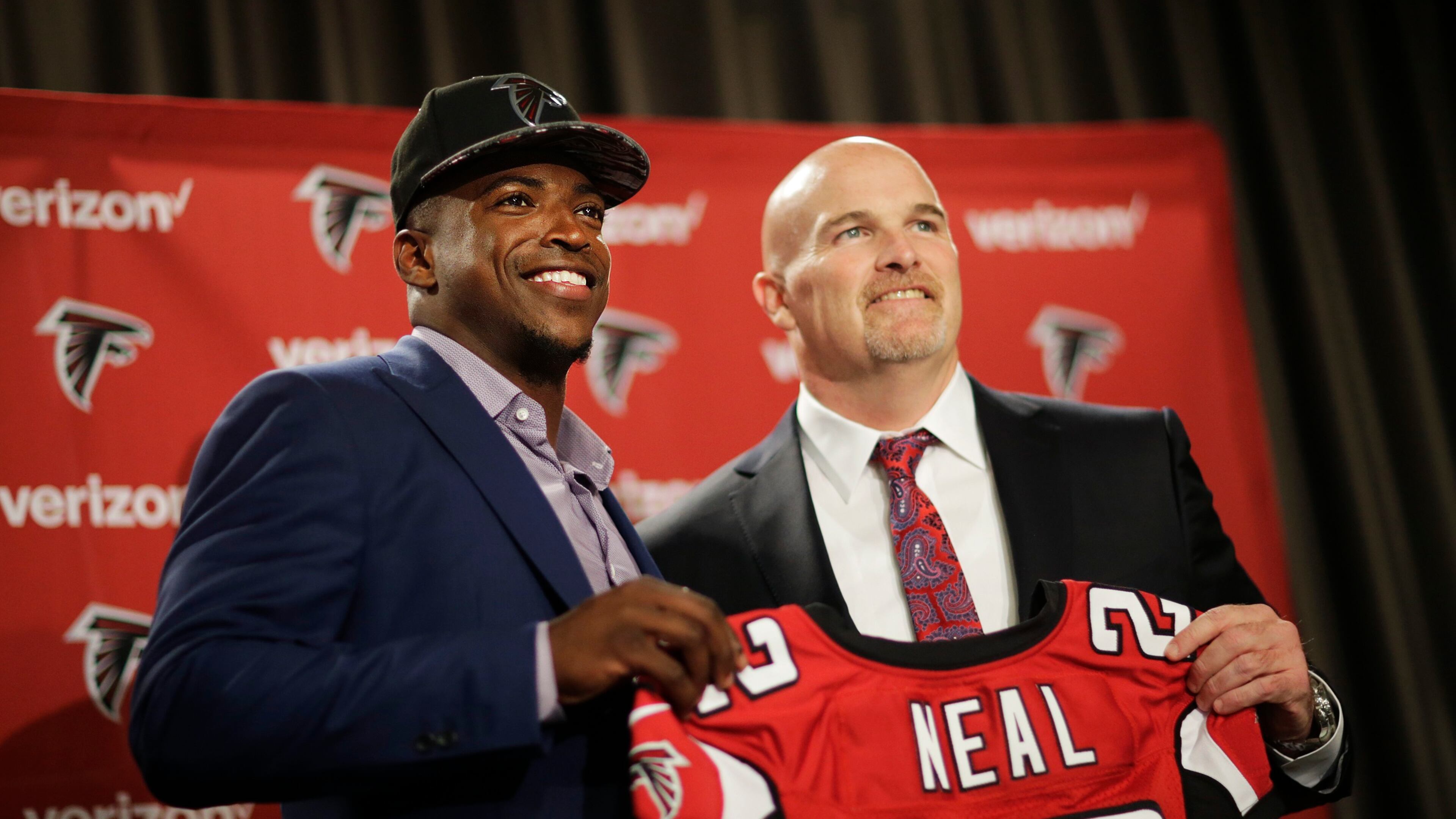 Atlanta Falcons first round draft pick Keanu Neal, left, poses for a photo with his jersey and head coach Dan Quinn following a news conference at the football team's practice facility Friday, April 29, 2016, in Flowery Branch, Ga. (AP Photo/David Goldman)