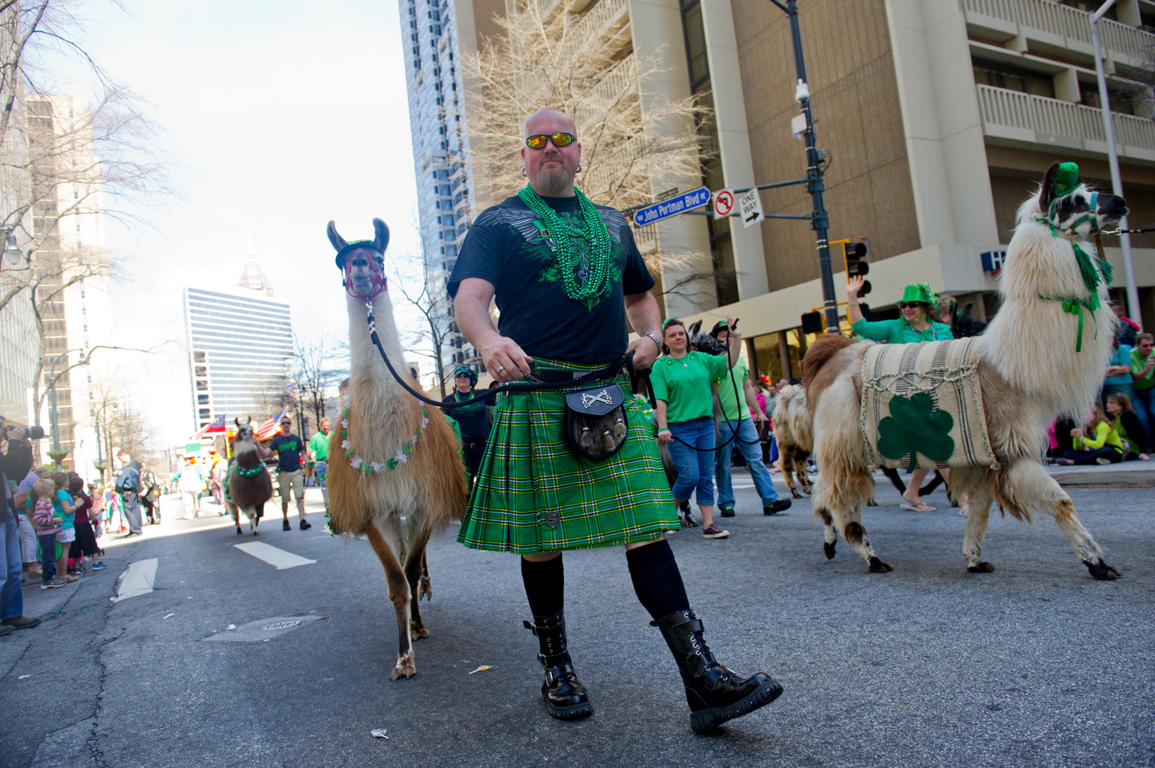Liam Munroe (center) leads his llama Echo down Peachtree Street during the 131st Atlanta St. Patrick's Day Parade on Saturday March 16, 2013.