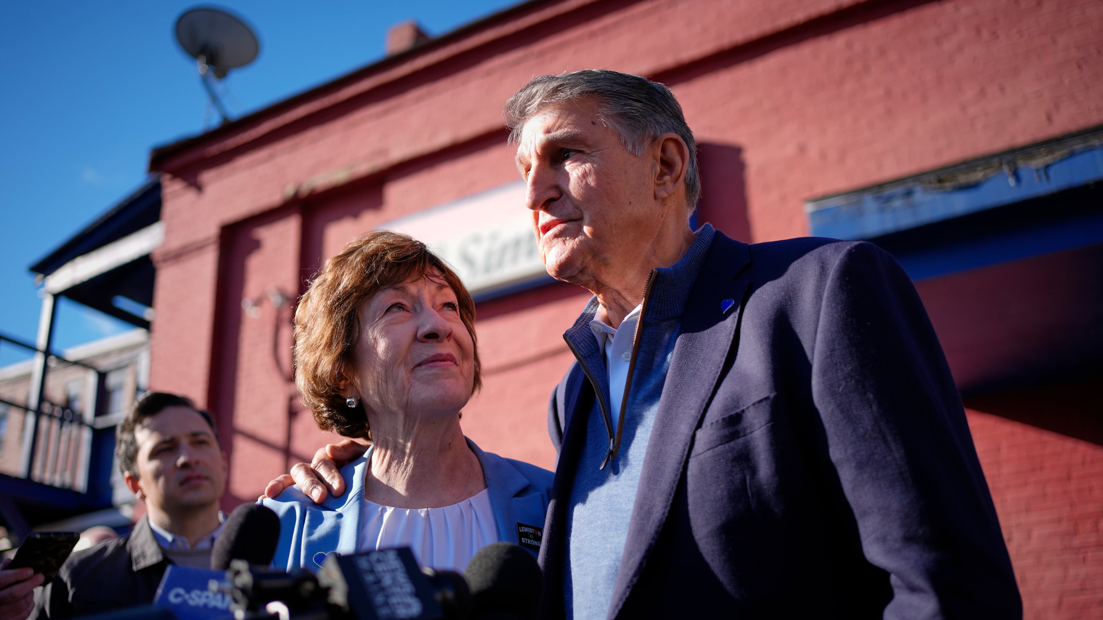 Sen. Susan Collins listens as former West Virginia Sen. Joe Manchin speaks to reporters following a campaign stop Wednesday, Oct. 21, 2026, in Lewiston, Maine. (AP Photo/Robert F. Bukaty)