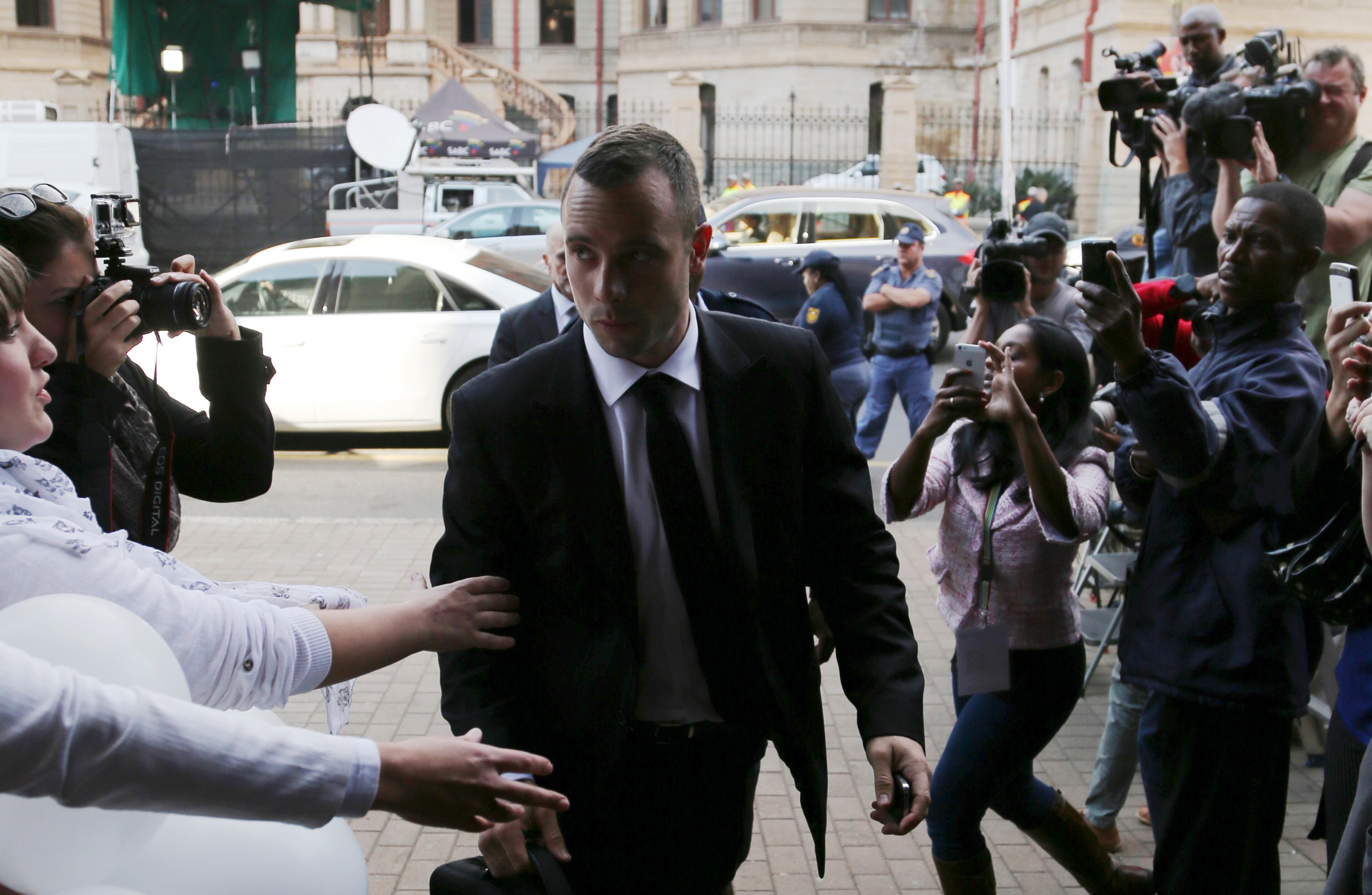 Oscar Pistorius is greetted by fans upon his arrival at the high court in Pretoria, South Africa, Friday, May 9, 2014. Pistorius is charged with murder for the shooting death of his girlfriend, Reeva Steenkamp, on Valentines Day in 2013. (AP Photo/Themba Hadebe)