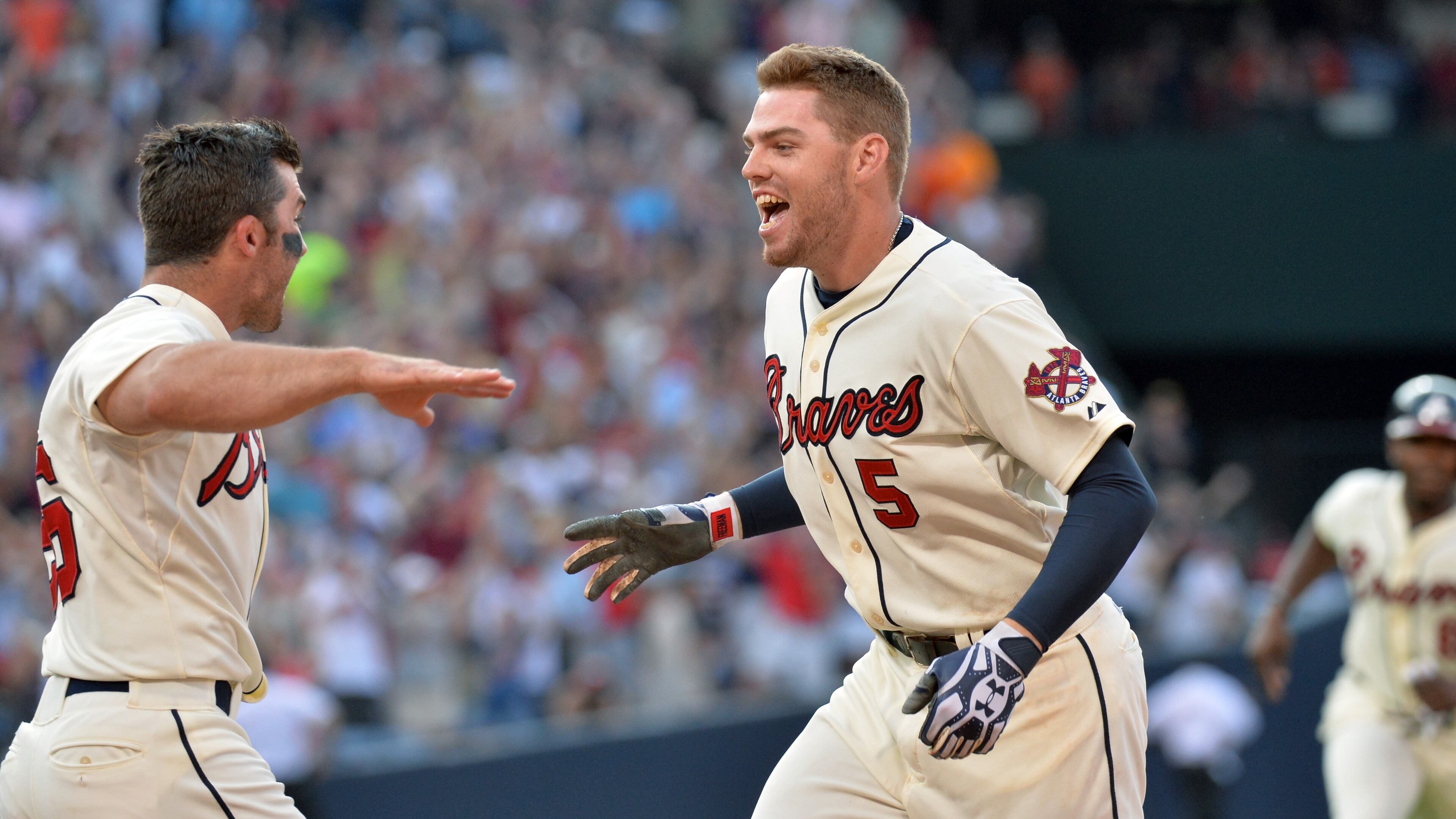Braves first baseman Freddie Freeman (5) is congratulated by Atlanta Braves second baseman Dan Uggla (left) after his game winning single in the 9th inning against the San Francisco Giants at Turner Field in Atlanta on Saturday, June 15, 2013. Atlanta Braves won 6-5 over the San Francisco Giants.