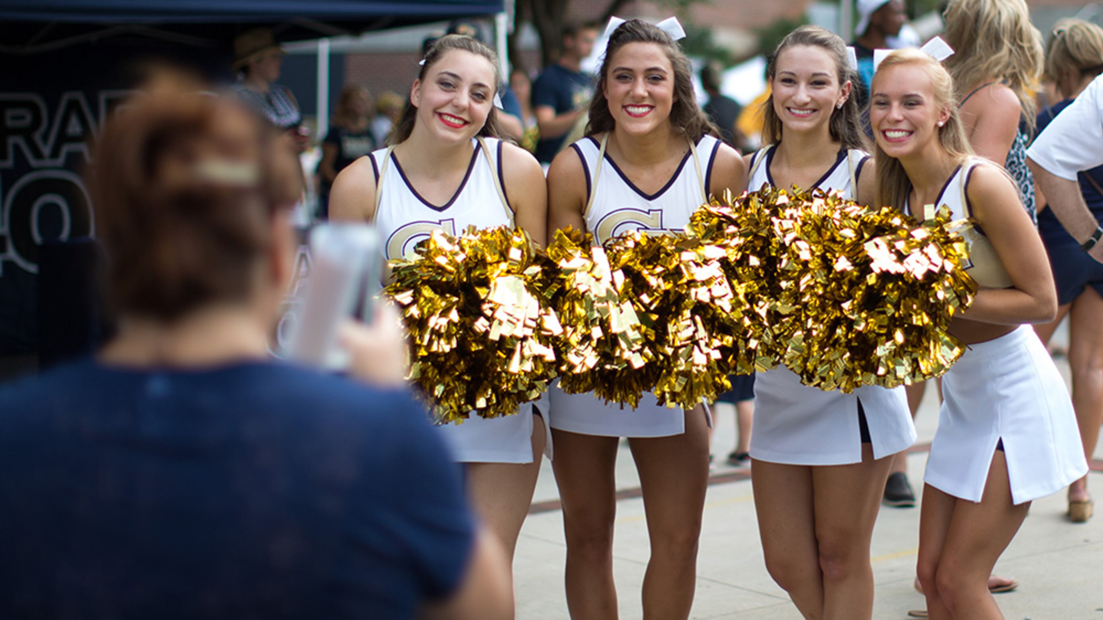 Kitty Shipp (left) takes a photo of Georgia Tech cheerleaders during the Jackets' annual fan day at Callaway Plaza outside of Bobby Dodd Stadium, Saturday, Aug. 8, 2015, in Atlanta.