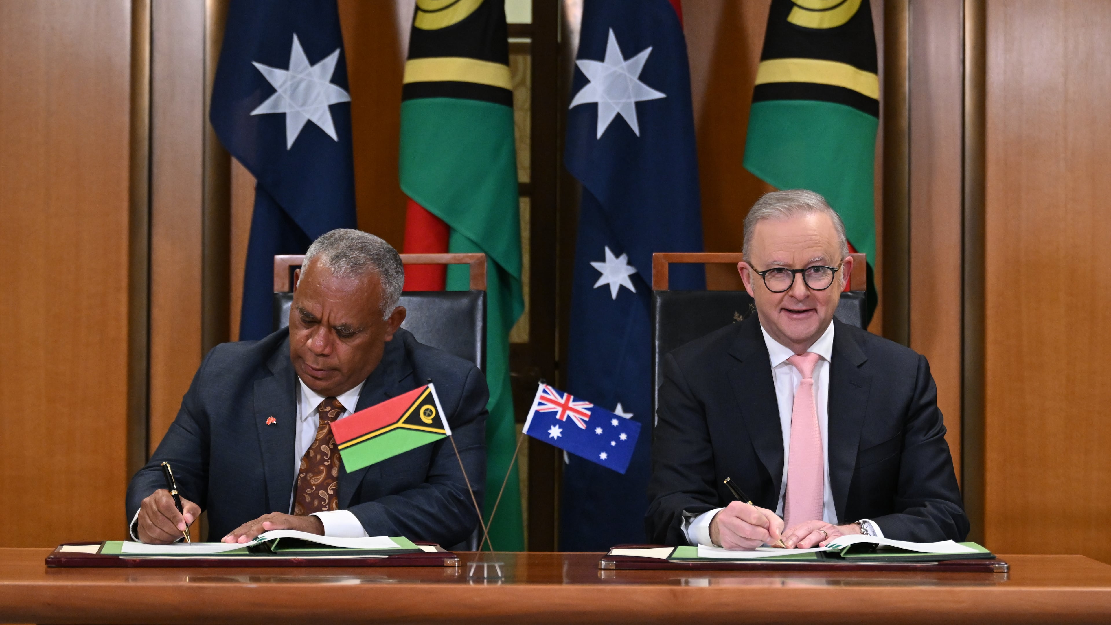 Prime Minister of Vanuatu Jotham Napat, left, and Australian Prime Minister Anthony Albanese sign the Nakamal agreement at Parliament House in Canberra, Monday, June 29, 2026. (Lukas Coch/AAP Image via AP)