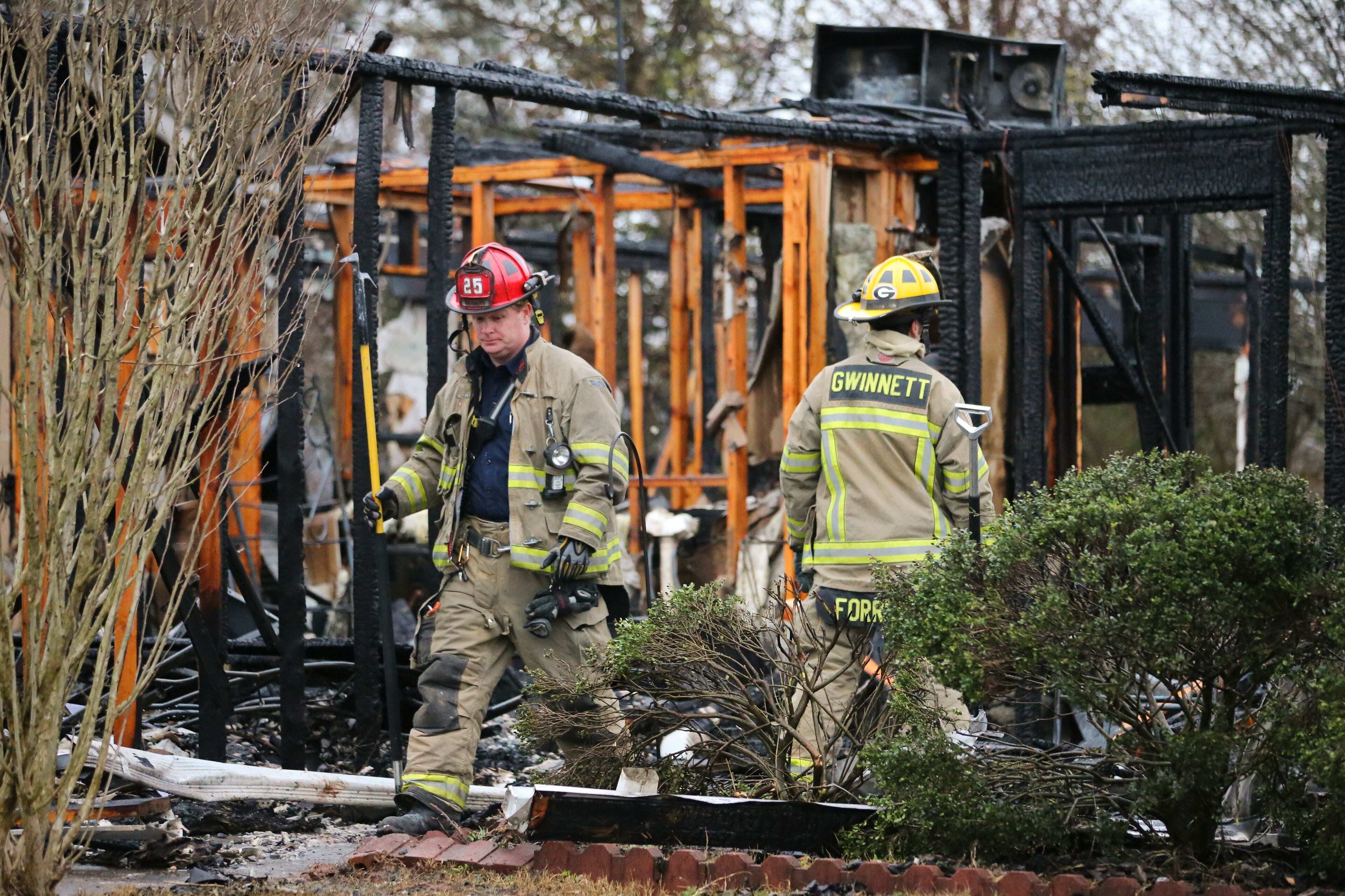 Gwinnett County firefighters check for hot spots. Thirteen people were displaced in a predawn fire that damaged four homes in a neighborhood near Lawrenceville.