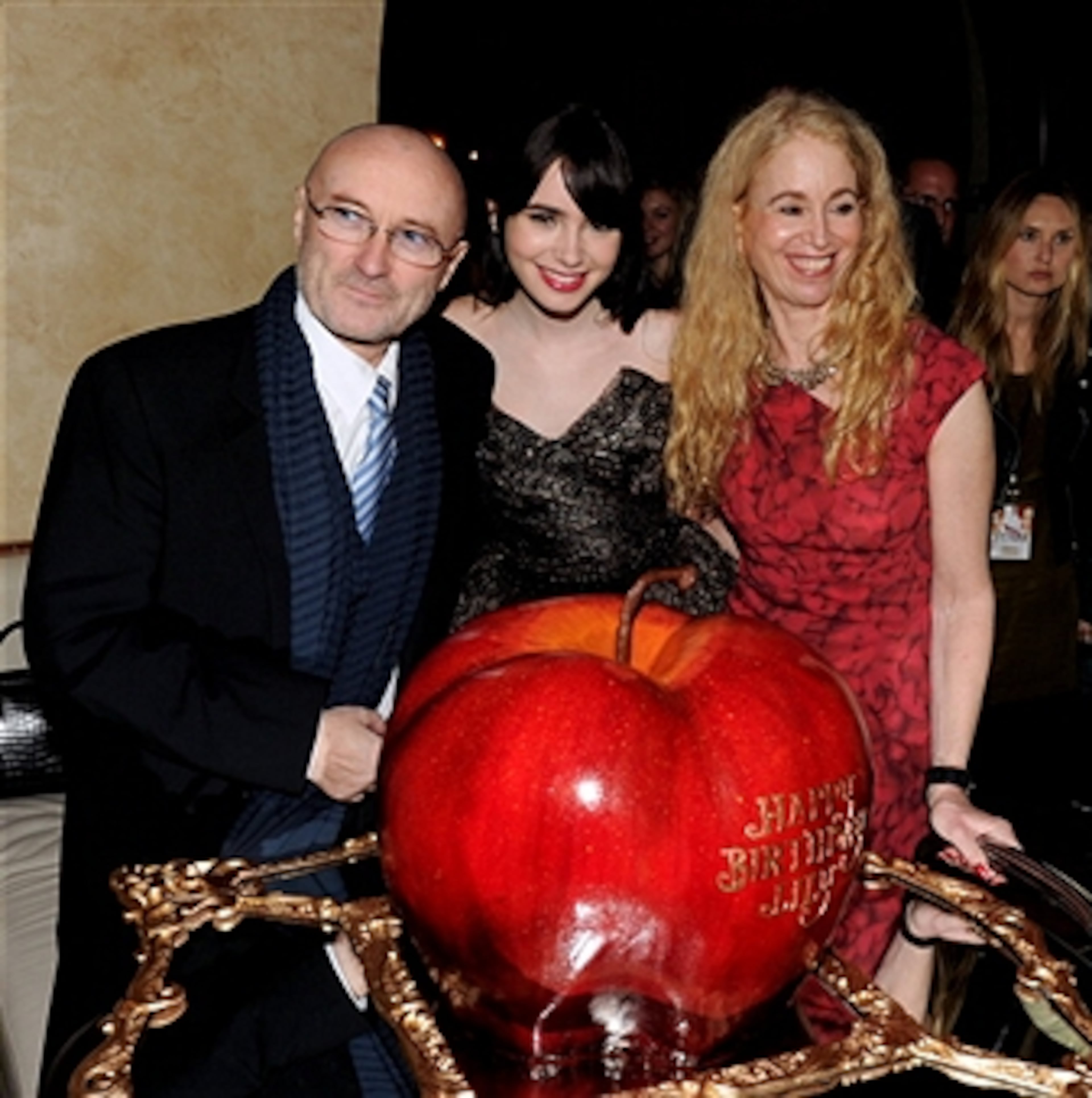 LOS ANGELES, CA - MARCH 17: (L-R) Musician Phil Collins, his daughter actress Lily Collins and her mom Jill Tavelman pose with Lily's birthday cake at the after party for the premiere of Relativity Media's 'Mirror Mirror' at the Hollywood Roosevelt Hotel on March 17, 2012 in Los Angeles, California. (Photo by Kevin Winter/Getty Images)