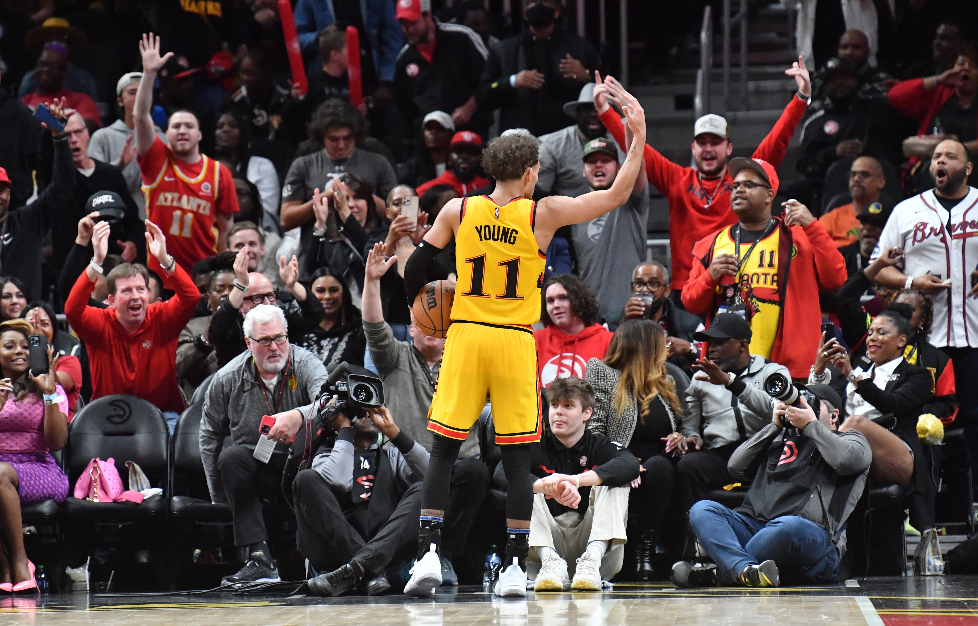 Hawks' guard Trae Young (11) encourages fans at the end of the 4th quarter in an NBA basketball game at State Farm Arena on Friday, March 25, 2022. Atlanta Hawks won 121-110 over Golden State Warriors. (Hyosub Shin / Hyosub.Shin@ajc.com)