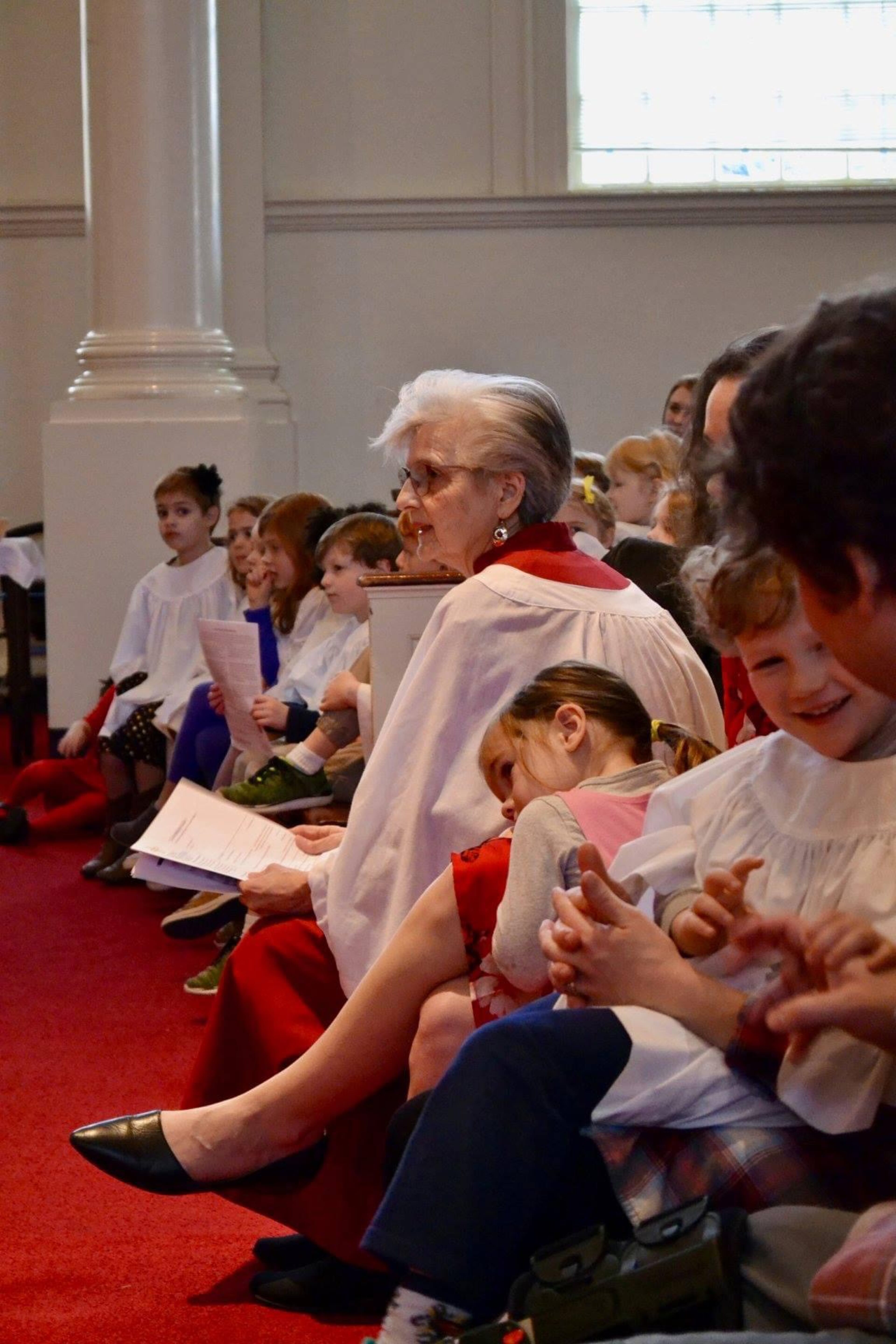 Mary Lindsey Lewis, leader of the Cherub Choir at Glenn Memorial United Methodist Church, sits with her young students.