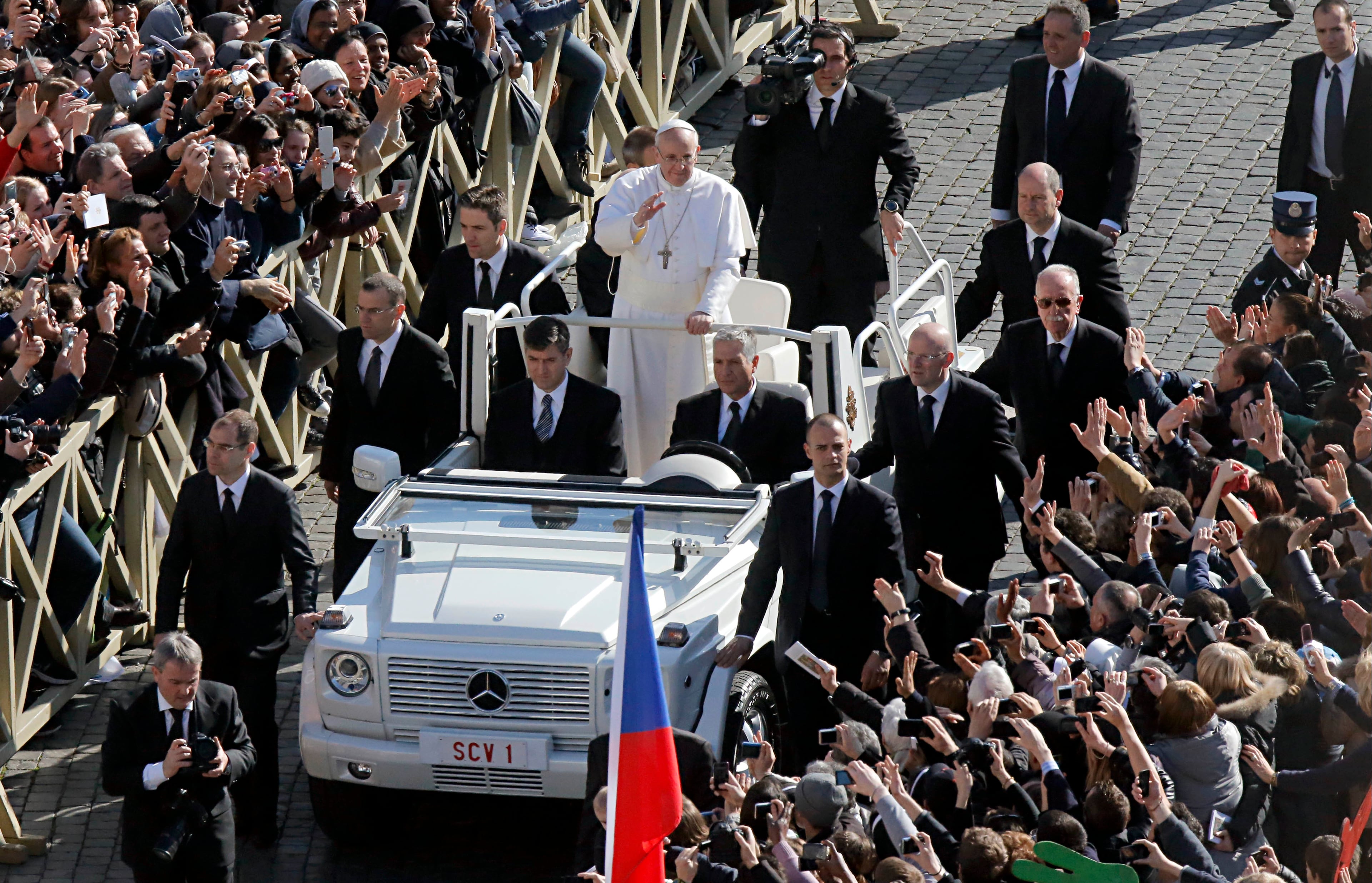 Pope Francis waves as he is driven through the crowd prior to his inaugural Mass, in St. Peter's Square at the Vatican, Tuesday, March 19, 2013. Pope Francis thrilled tens of thousands of people on Tuesday gathered for his installation Mass, taking a long round-about through St. Peter's Square and getting out of his jeep to bless a disabled man in a wheelchair in the crowd. (AP Photo/Dmitry Lovetsky)