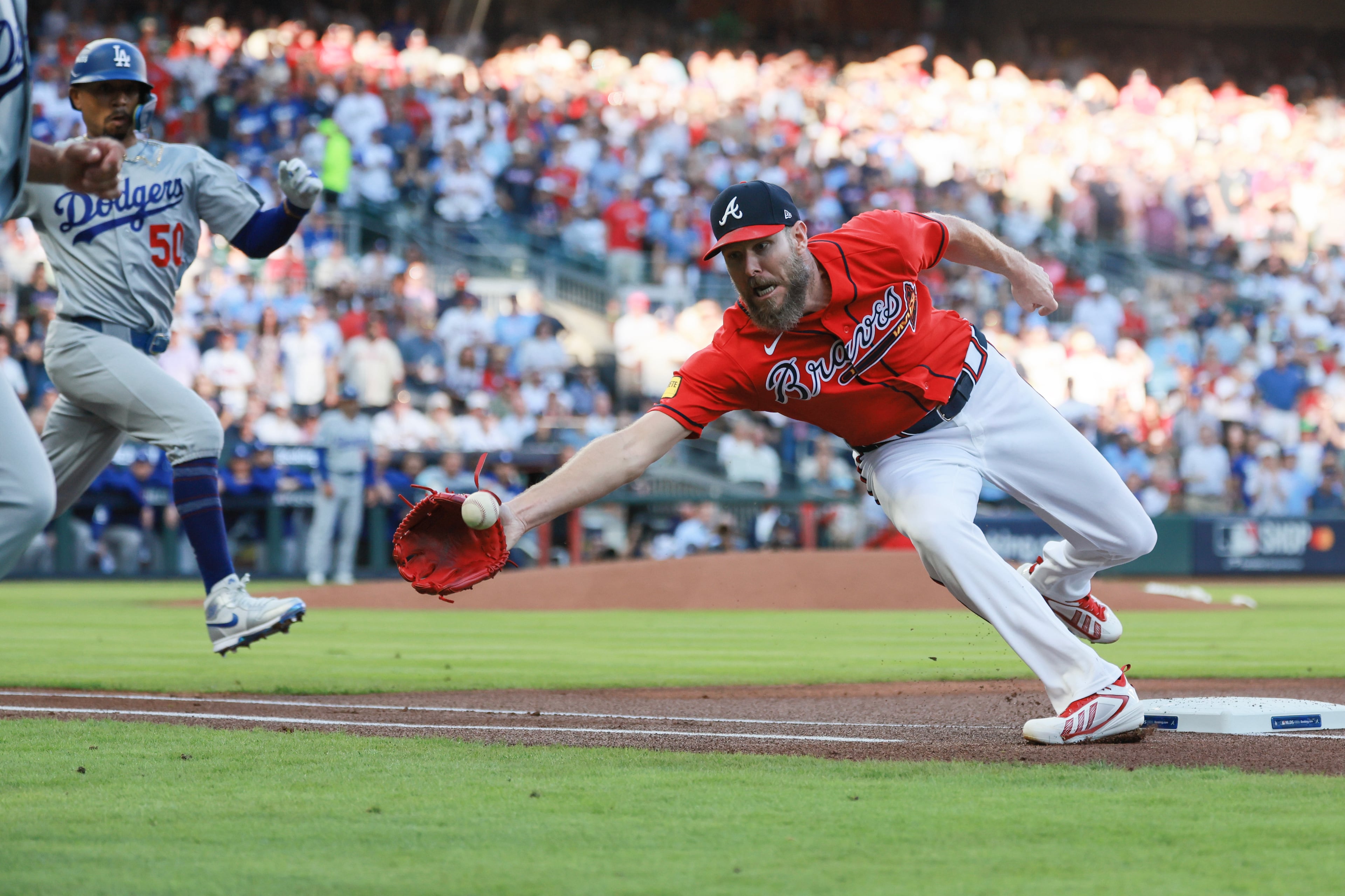 Atlanta Braves pitcher Chris Sale, right, misses the catch from first baseman Matt Olson on an infield hit by Los Angeles Dodgers shortstop Mookie Betts (50) during the first inning of Game 3 of the MLB National League Division Series between the Atlanta Braves and the Los Angeles Dodgers, Tuesday, Oct. 6, 2026, in Atlanta. (Jason Getz/AJC)