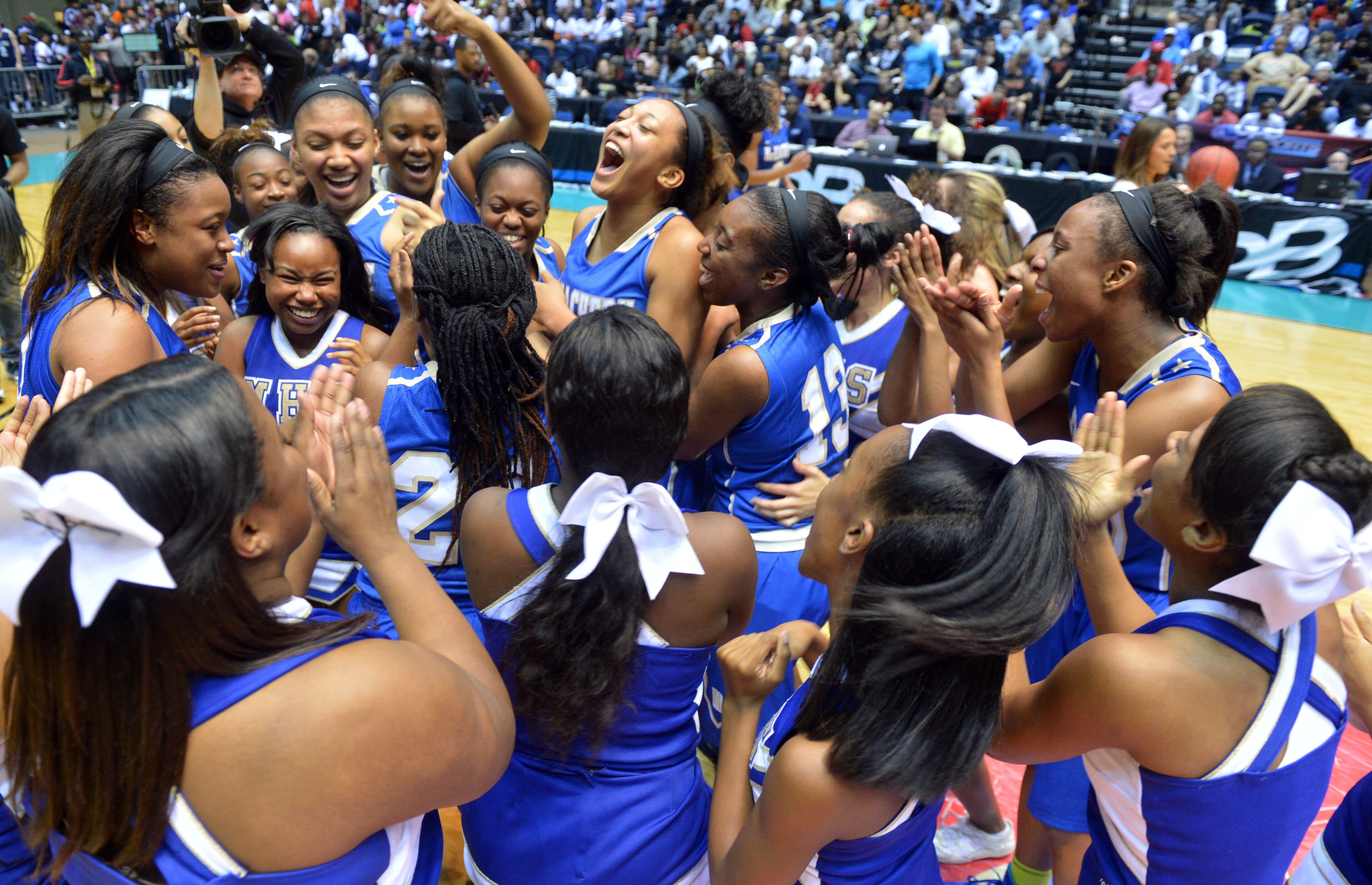 McEachern Indians players and cheerleaders celebrate after the game. Coverage of the Class AAAAAA girls basketball championship between the McEachern Indians and Archer Tigers at the Macon Coliseum Saturday, March 8, 2014. McEachearn won, beating Archer, 81-62.