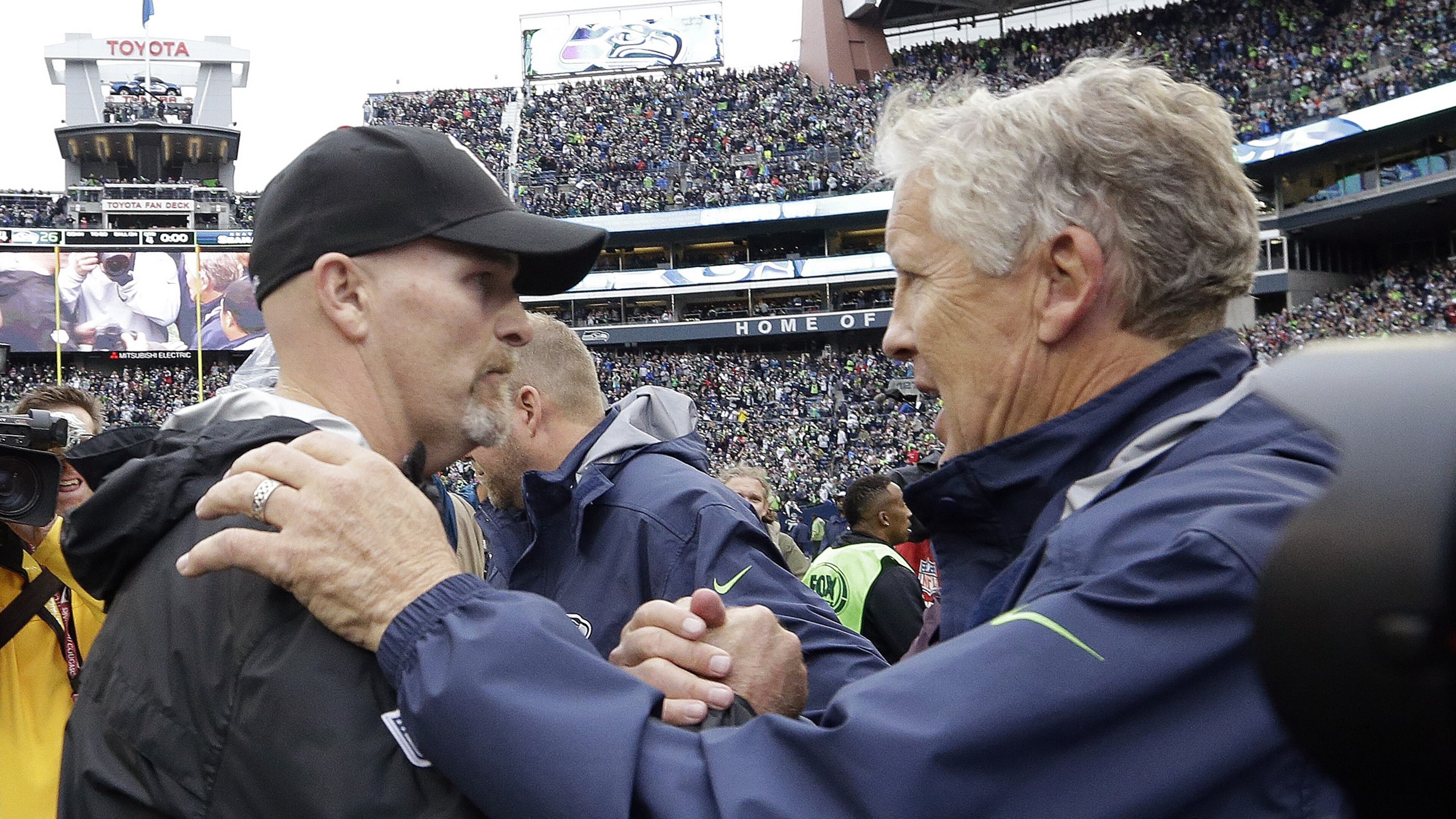 Seattle Seahawks coach Pete Carroll, right, greets Falcons coach Dan Quinn after an NFL football game, Sunday, Oct. 16, 2016, in Seattle. (AP Photo/Elaine Thompson)