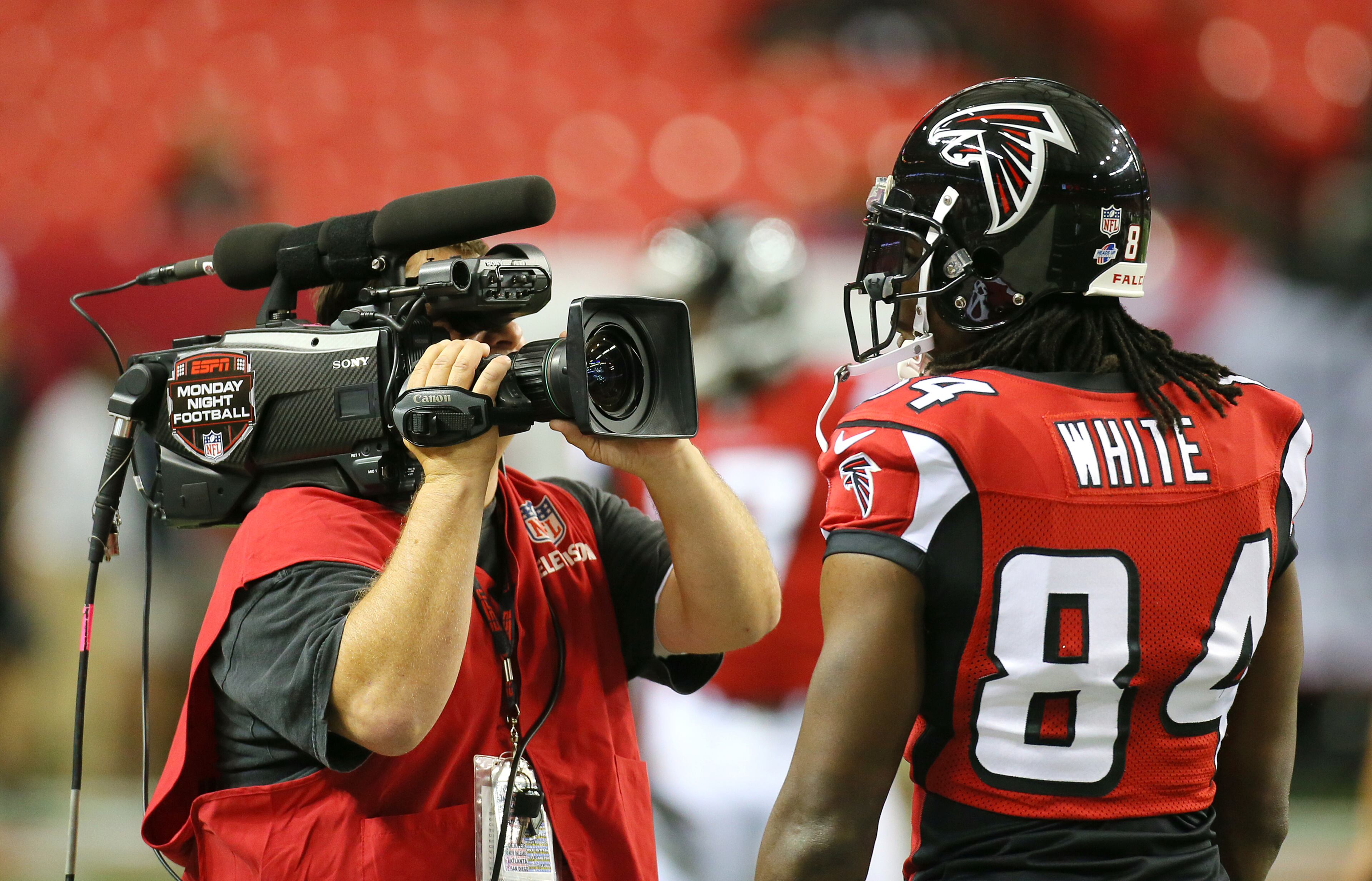 A ESPN camera man gets close while wide receiver Roddy White warms up for the Falcons NFL exhibition game.