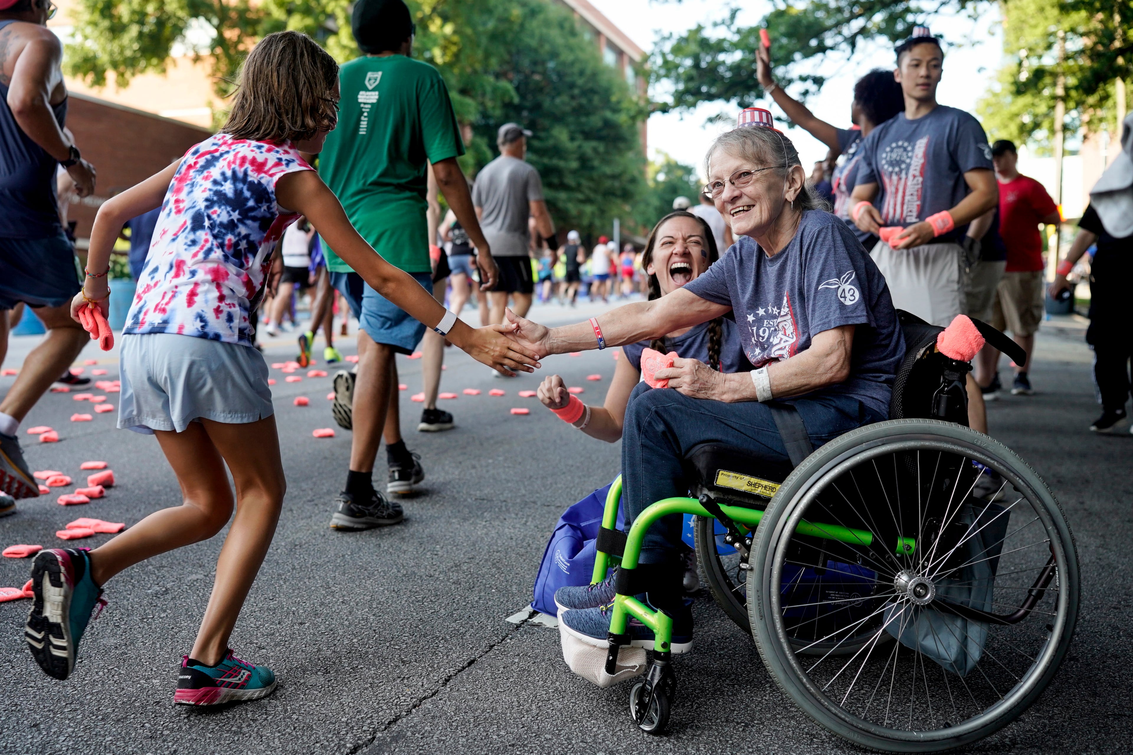 Patients at the Shepherd Center welcome runners during the 55th running of The Atlanta Journal-Constitution Peachtree Road Race.